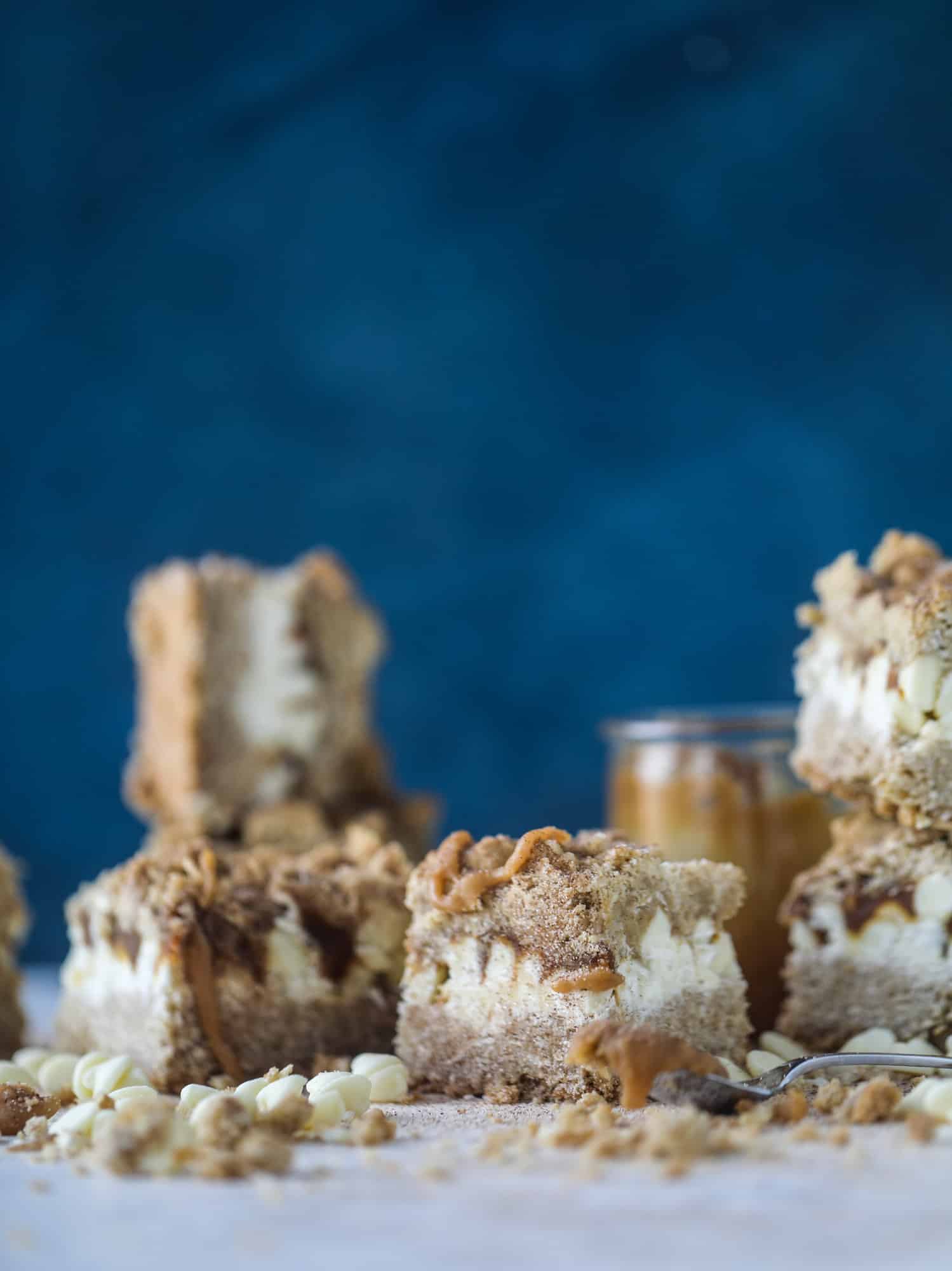 These snickerdoodle caramelitas have a layer of chewy, cinnamon sugared oatmeal bar topped with cream white chocolate and more crumbly, chewy oatmeal bites. They are super delicious and festive! I howsweeteats.com #snickerdoodle #caramelitas