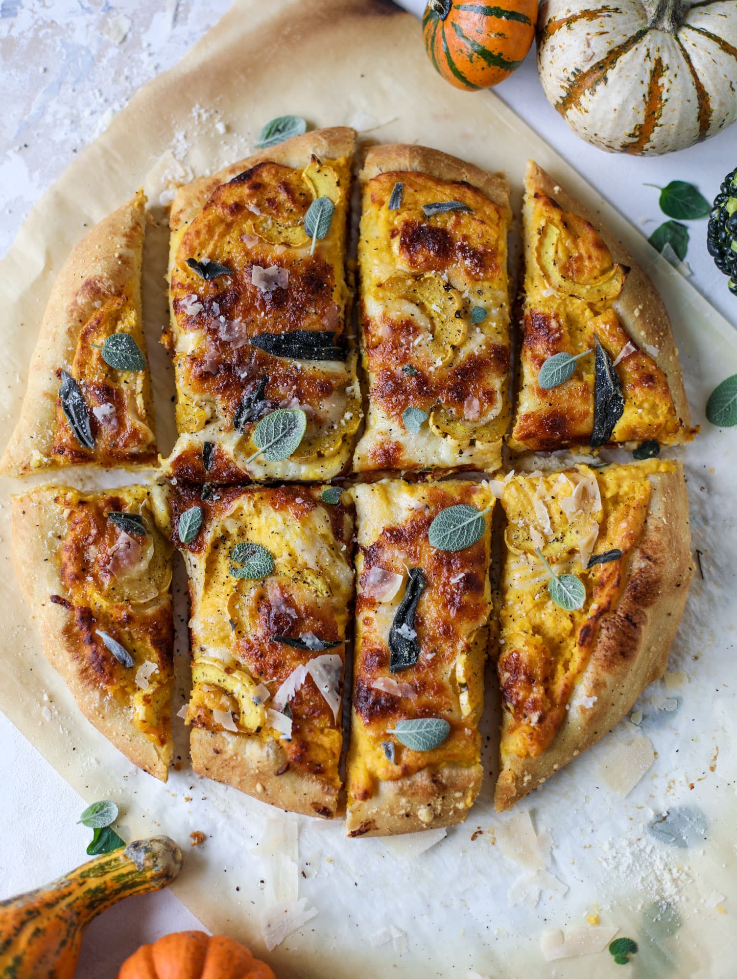 This butternut squash pizza has all the perfect tastes of fall in a pizza! Creamy butternut squash base, sharp parmesan cheese, crispy, fresh sage - it's all these and so super flavorful. It's easy too! I howsweeteats.com #butternutsquash #pizza