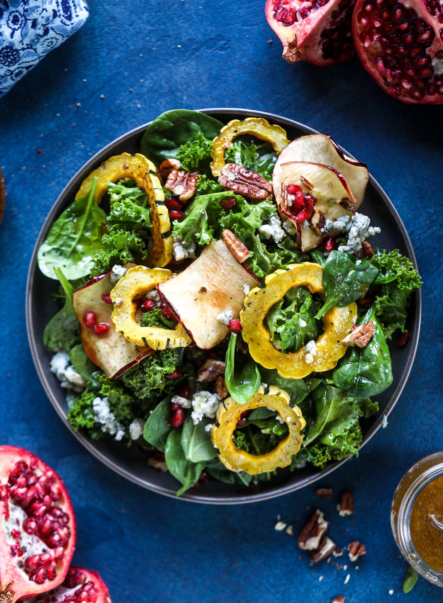 This thanksgiving salad is full of so much autumn flavor. It has toasted pomegranate, delicata squash, toasted pecans, creamy blue cheese and crunchy apple chips. It's light enough to serve before the big meal! I howsweeteats.com #thanksgiving #salad