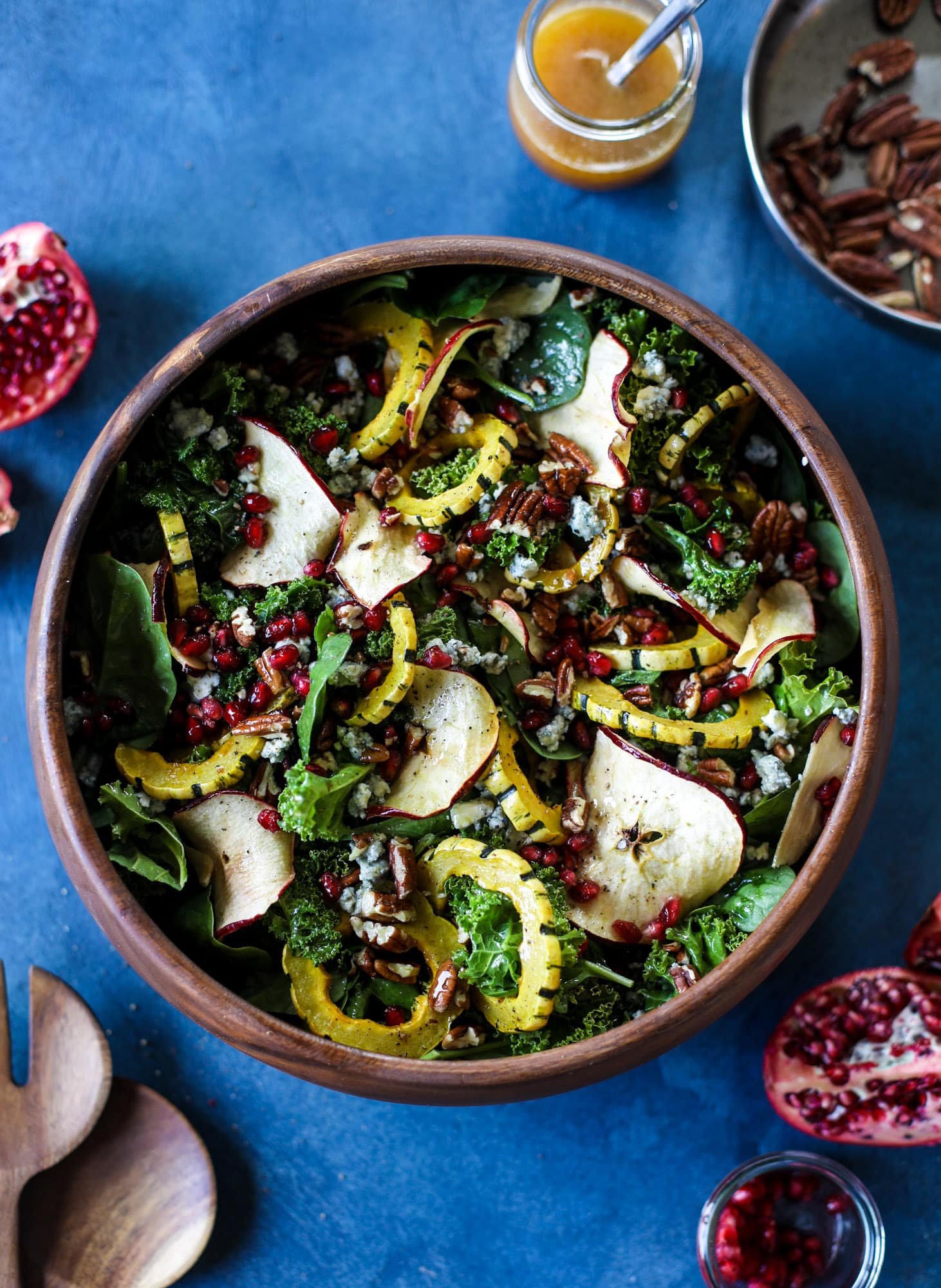 This thanksgiving salad is full of so much autumn flavor. It has toasted pomegranate, delicata squash, toasted pecans, creamy blue cheese and crunchy apple chips. It's light enough to serve before the big meal! I howsweeteats.com #thanksgiving #salad