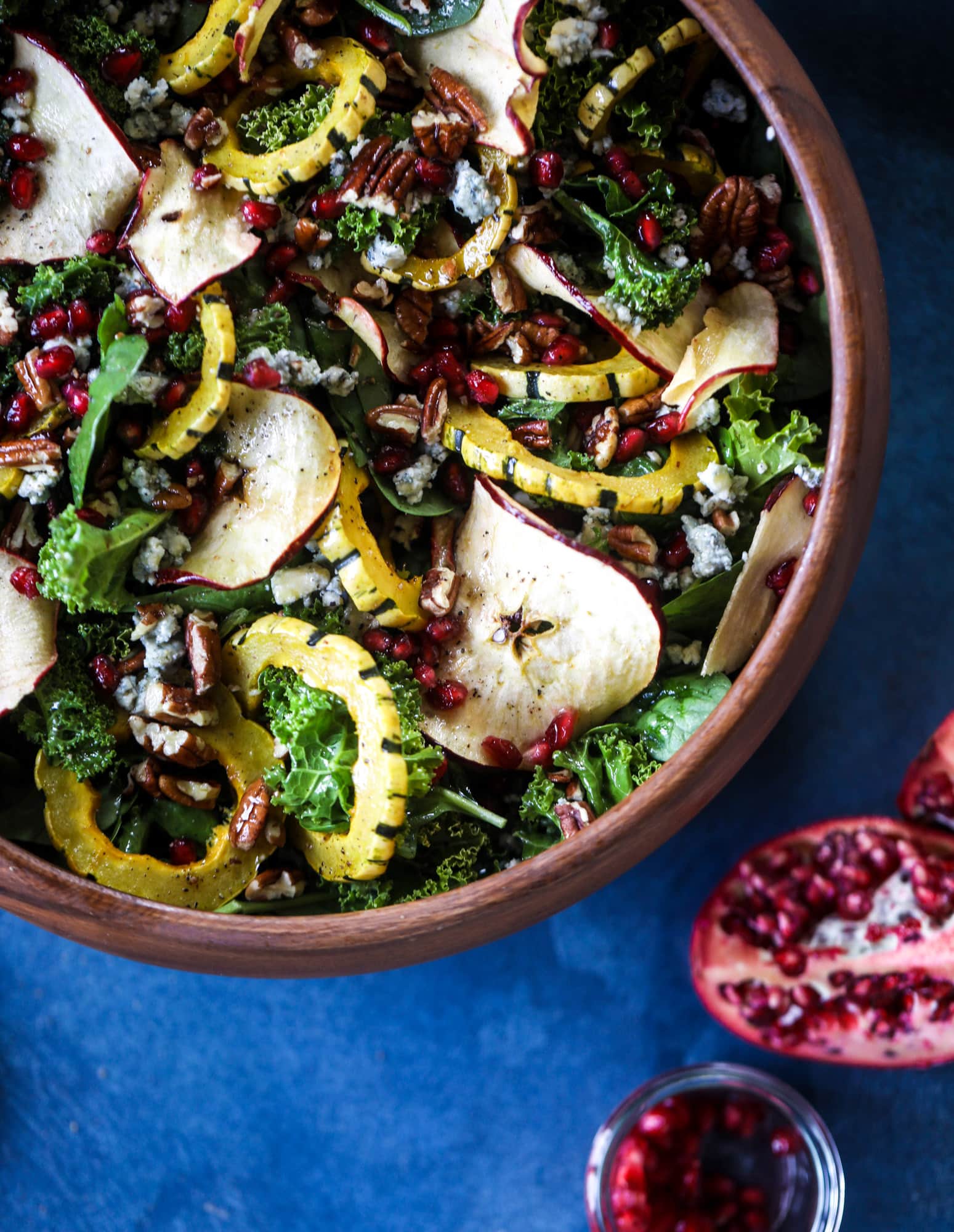 This thanksgiving salad is full of so much autumn flavor. It has toasted pomegranate, delicata squash, toasted pecans, creamy blue cheese and crunchy apple chips. It's light enough to serve before the big meal! I howsweeteats.com #thanksgiving #salad