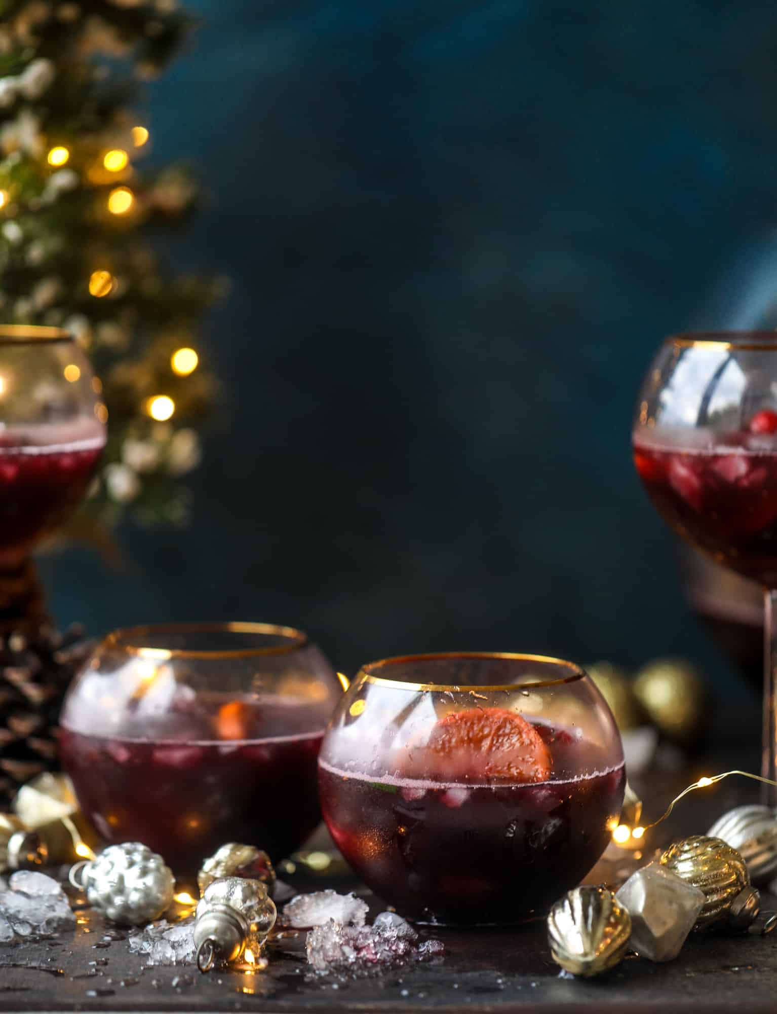 This tree trimming punch is the most perfect christmas punch to drink while decorating the tree! Rich red wine is the base and there's a bit of orange, some spice, cinnamon and a gorgeous jeweled holiday ice cubes! I howsweeteats.com #christmas #punch