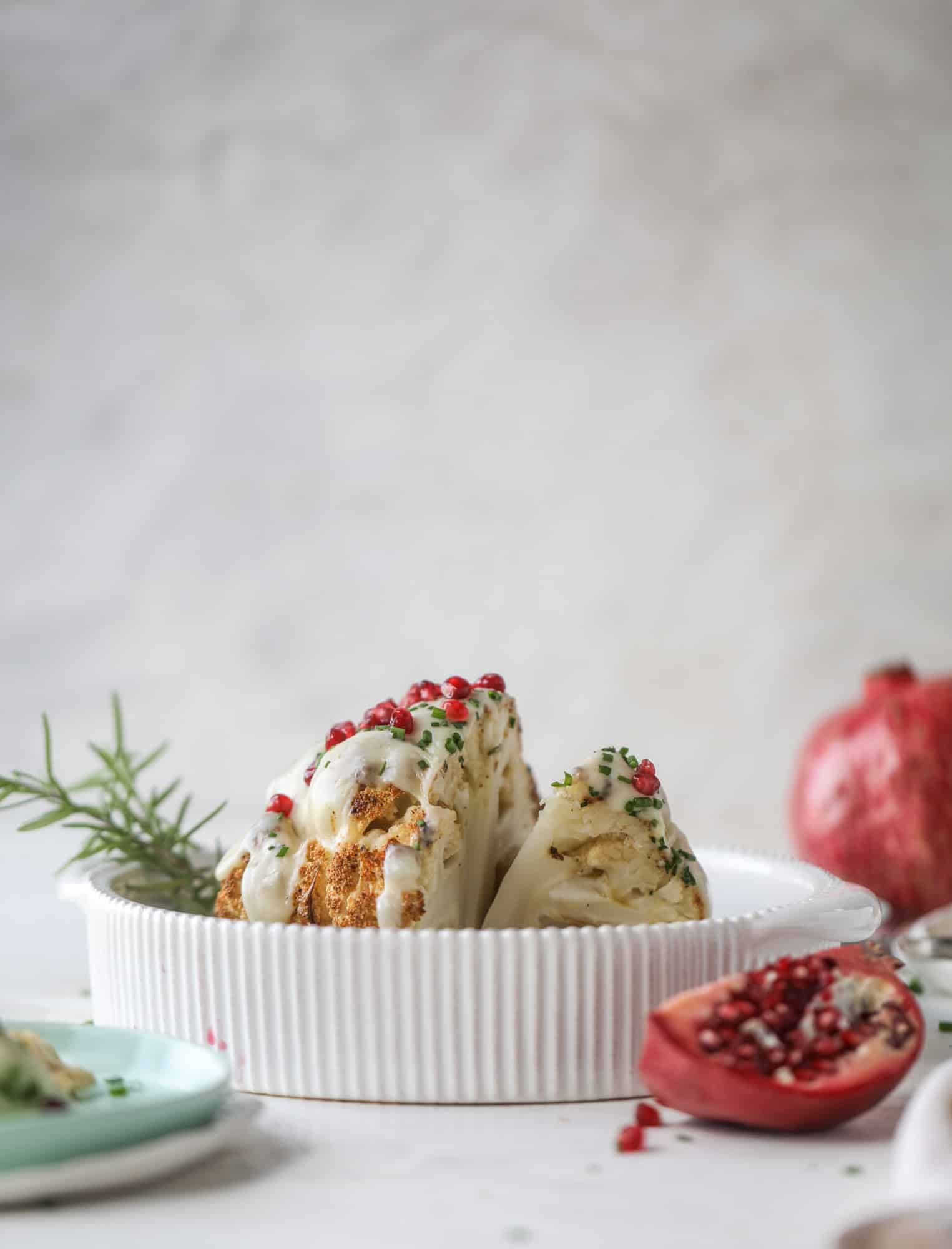 This whole roasted cauliflower fondue is roasted to toasty perfection and then covered in a fondue cheese sauce! Sprinkled with a festive garnish, it's the perfect appetizer or side dish for your dinner party, weeknight meal or movie night! I howsweeteats.com #wholeroasted #cauliflower