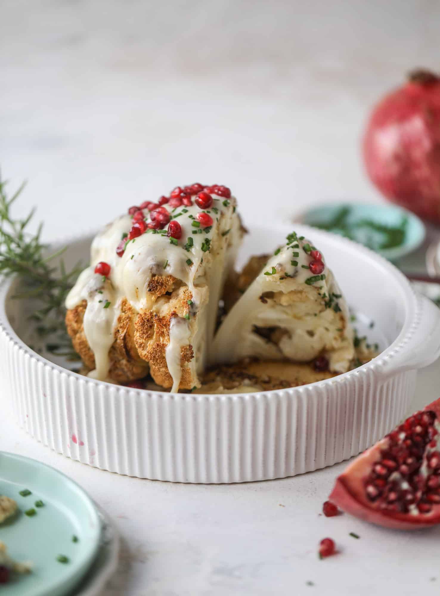 This whole roasted cauliflower fondue is roasted to toasty perfection and then covered in a fondue cheese sauce! Sprinkled with a festive garnish, it's the perfect appetizer or side dish for your dinner party, weeknight meal or movie night! I howsweeteats.com #wholeroasted #cauliflower