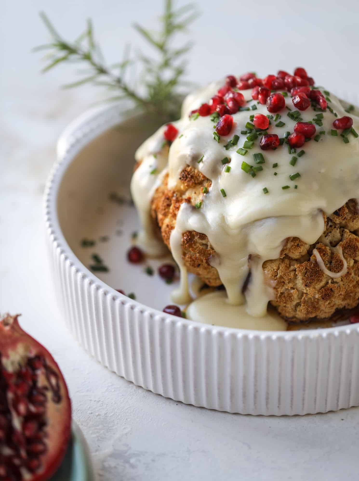 This whole roasted cauliflower fondue is roasted to toasty perfection and then covered in a fondue cheese sauce! Sprinkled with a festive garnish, it's the perfect appetizer or side dish for your dinner party, weeknight meal or movie night! I howsweeteats.com #wholeroasted #cauliflower