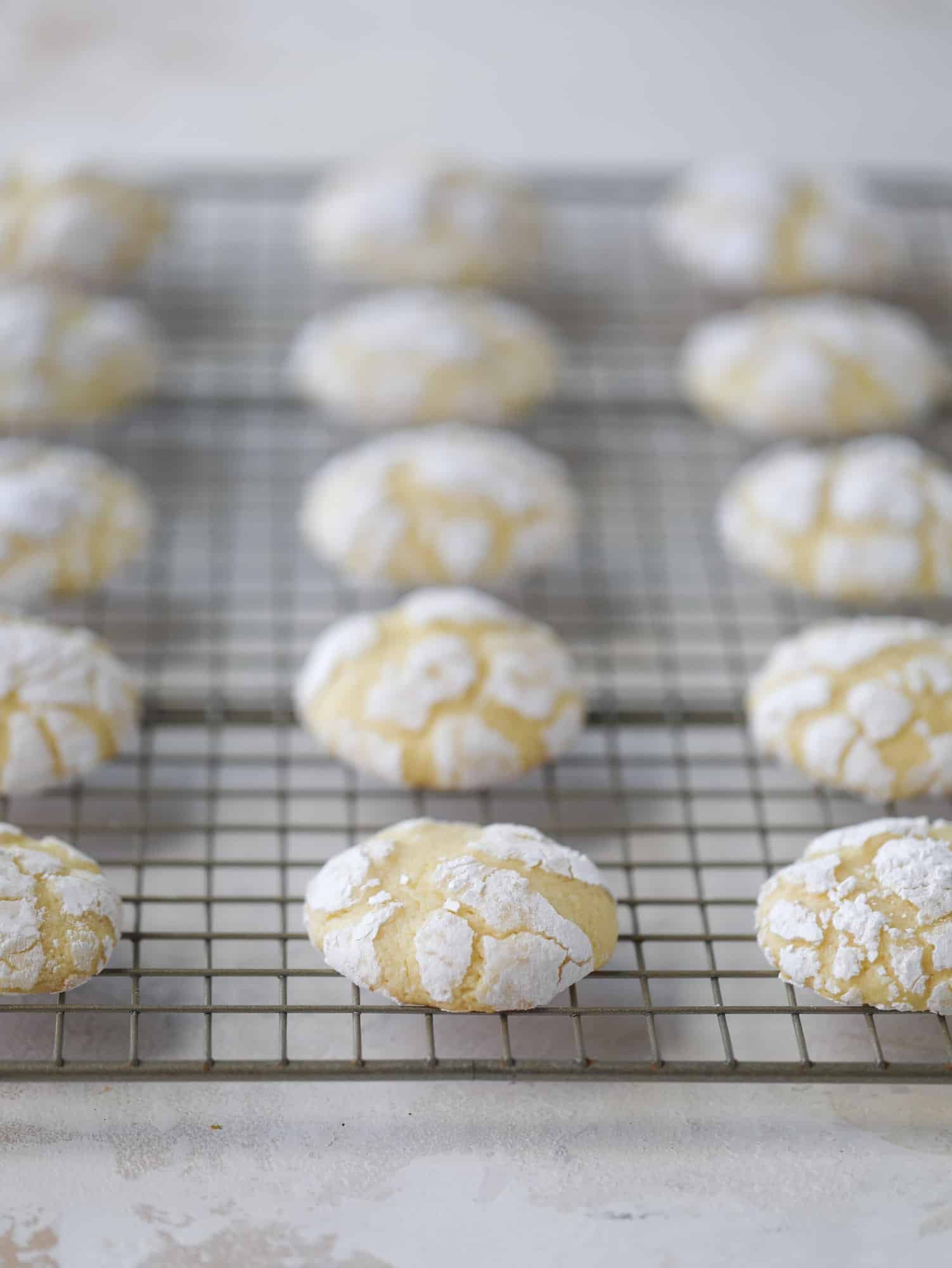 These lemon crinkle cookies are perfect if you love lemon desserts! They take after chocolate crinkle cookies, but are a delightful refreshing lemon flavor sprinkle with powdered sugar. These are always a huge hit! I howsweeteats.com #lemoncrinkle #cookies