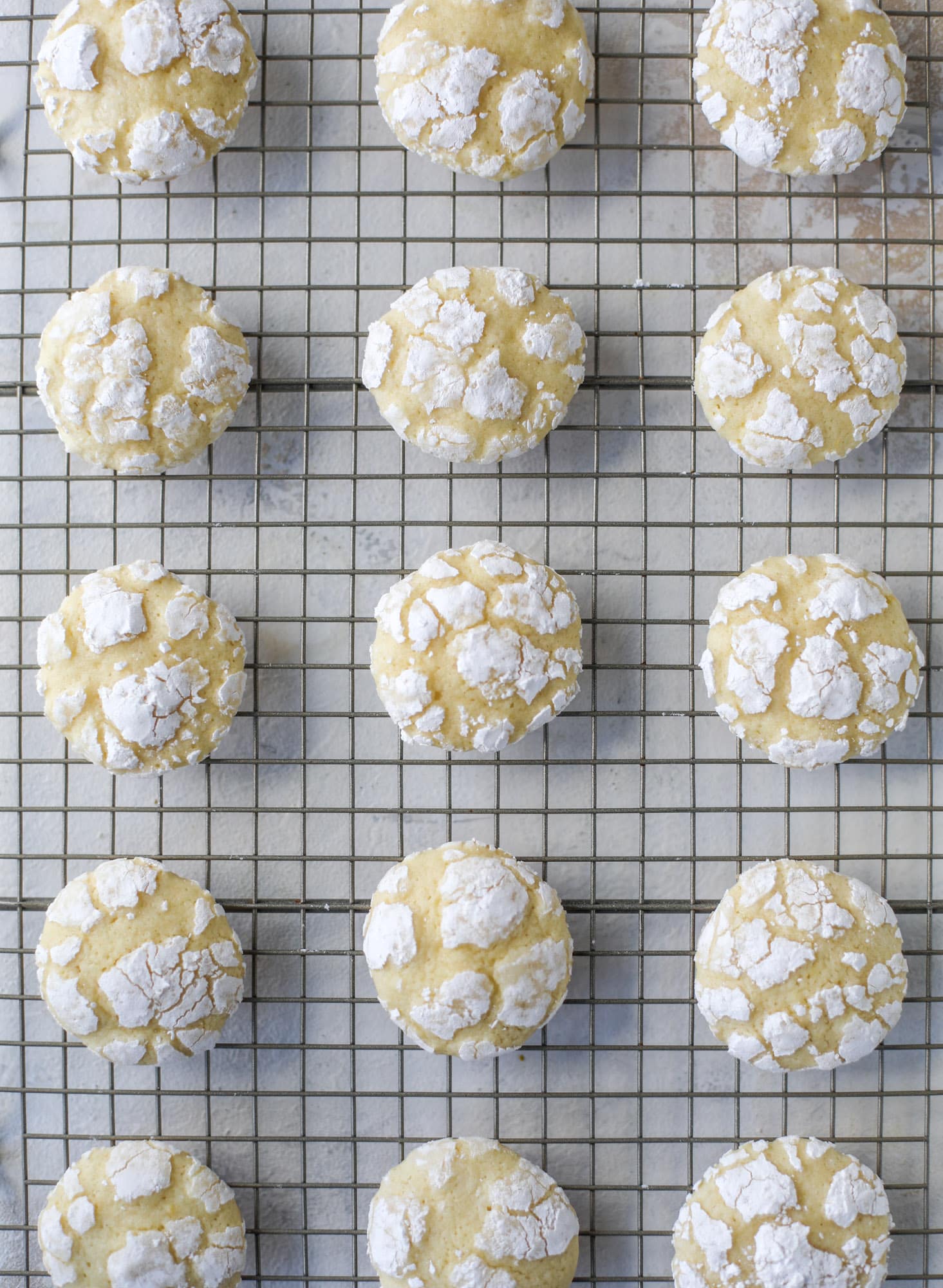 These lemon crinkle cookies are perfect if you love lemon desserts! They take after chocolate crinkle cookies, but are a delightful refreshing lemon flavor sprinkle with powdered sugar. These are always a huge hit! I howsweeteats.com #lemoncrinkle #cookies