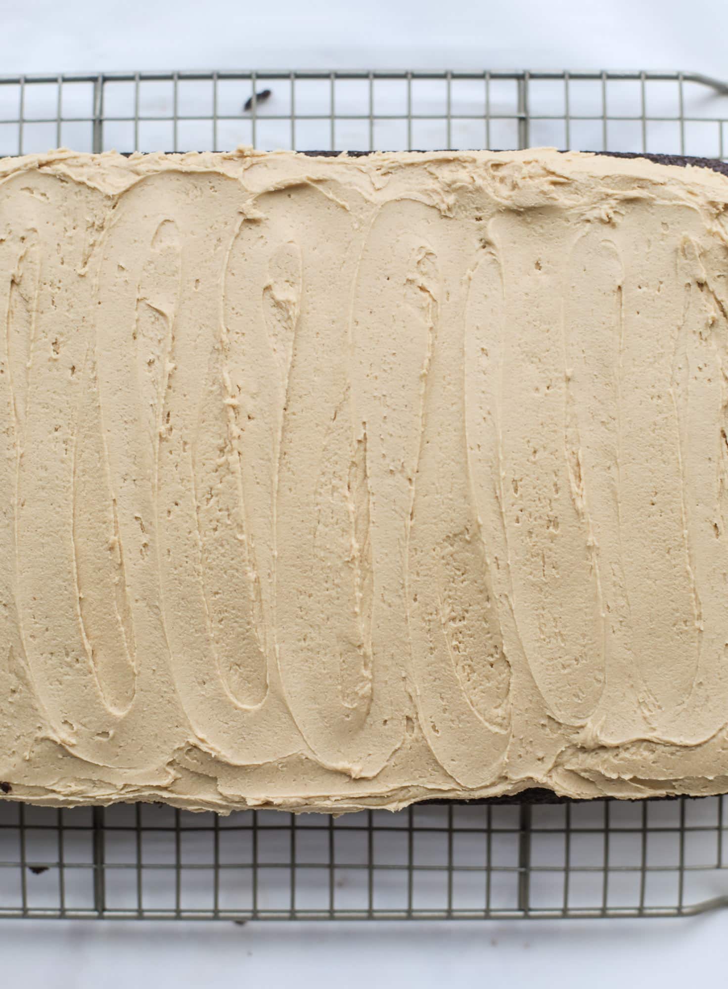 Easy chocolate peanut butter cake is the way to my heart. Moist chocolate cake, fluffy peanut butter frosting. It's the perfect dessert, anytime! I howsweeteats.com #chocolatepeanutbutter #cake