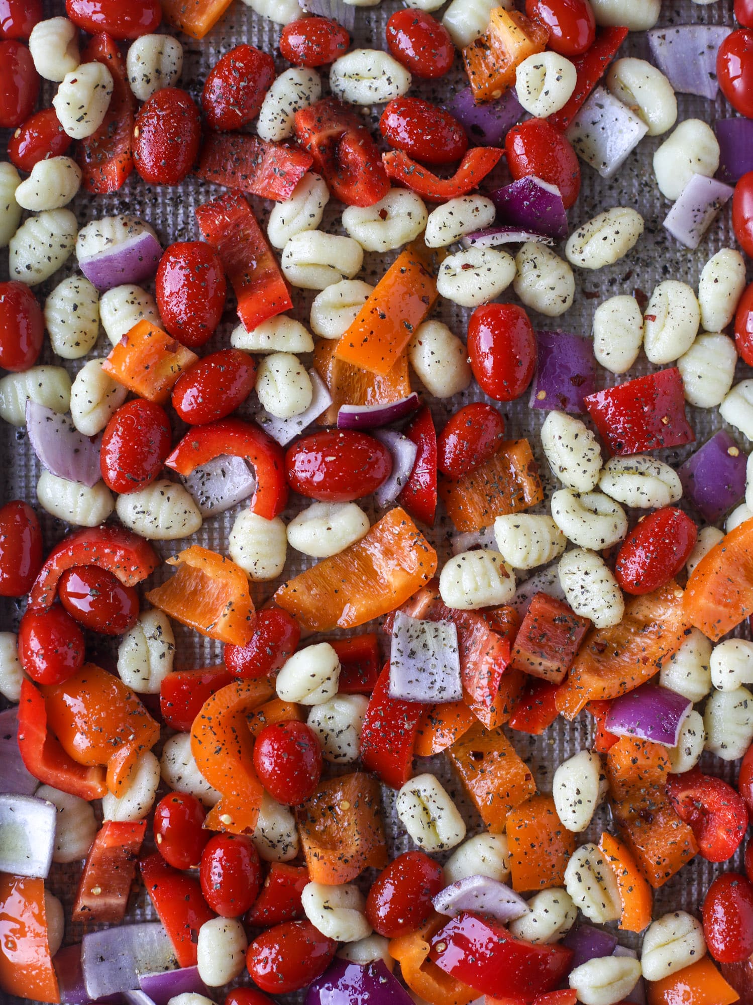 Sheet pan gnocchi is an easy meal that the whole family will love! Toasted gnocchi along with burst tomatoes and caramelized peppers makes the best dinner. I howsweeteats.com #sheetpan #gnocchi