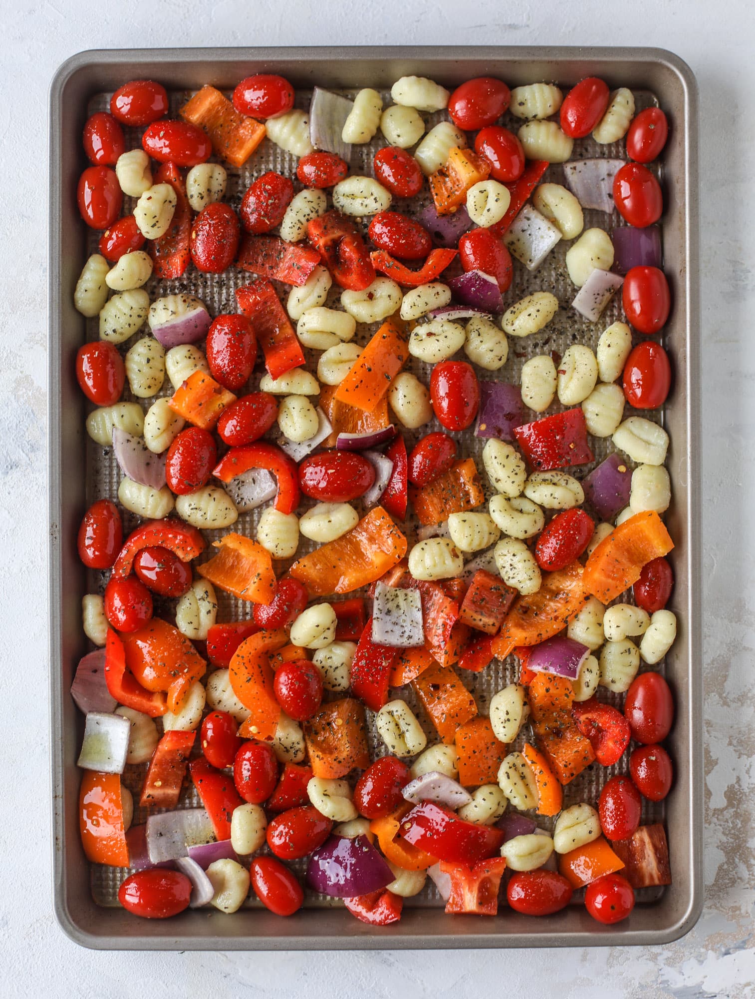 Sheet pan gnocchi is an easy meal that the whole family will love! Toasted gnocchi along with burst tomatoes and caramelized peppers makes the best dinner. I howsweeteats.com #sheetpan #gnocchi