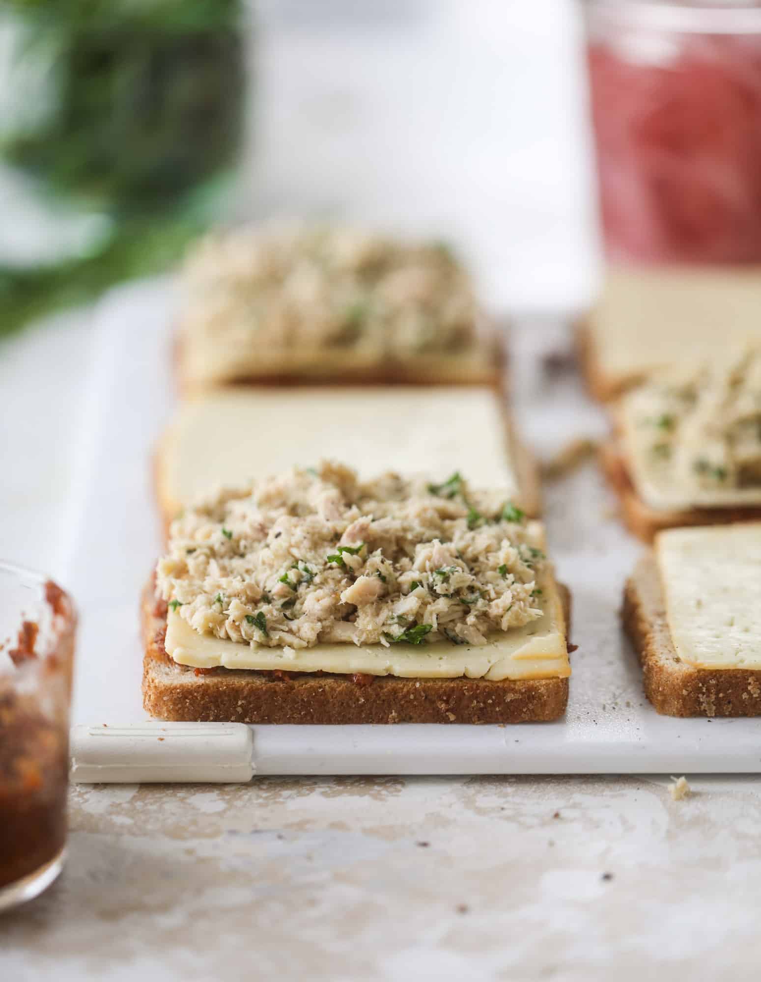 This tuscan tuna melt is a modern way to enjoy a tuna sandwich, with peppery arugula, melty cheese, pickled onions and sun dried tomato spread! I howsweeteats.com #tuna #melt