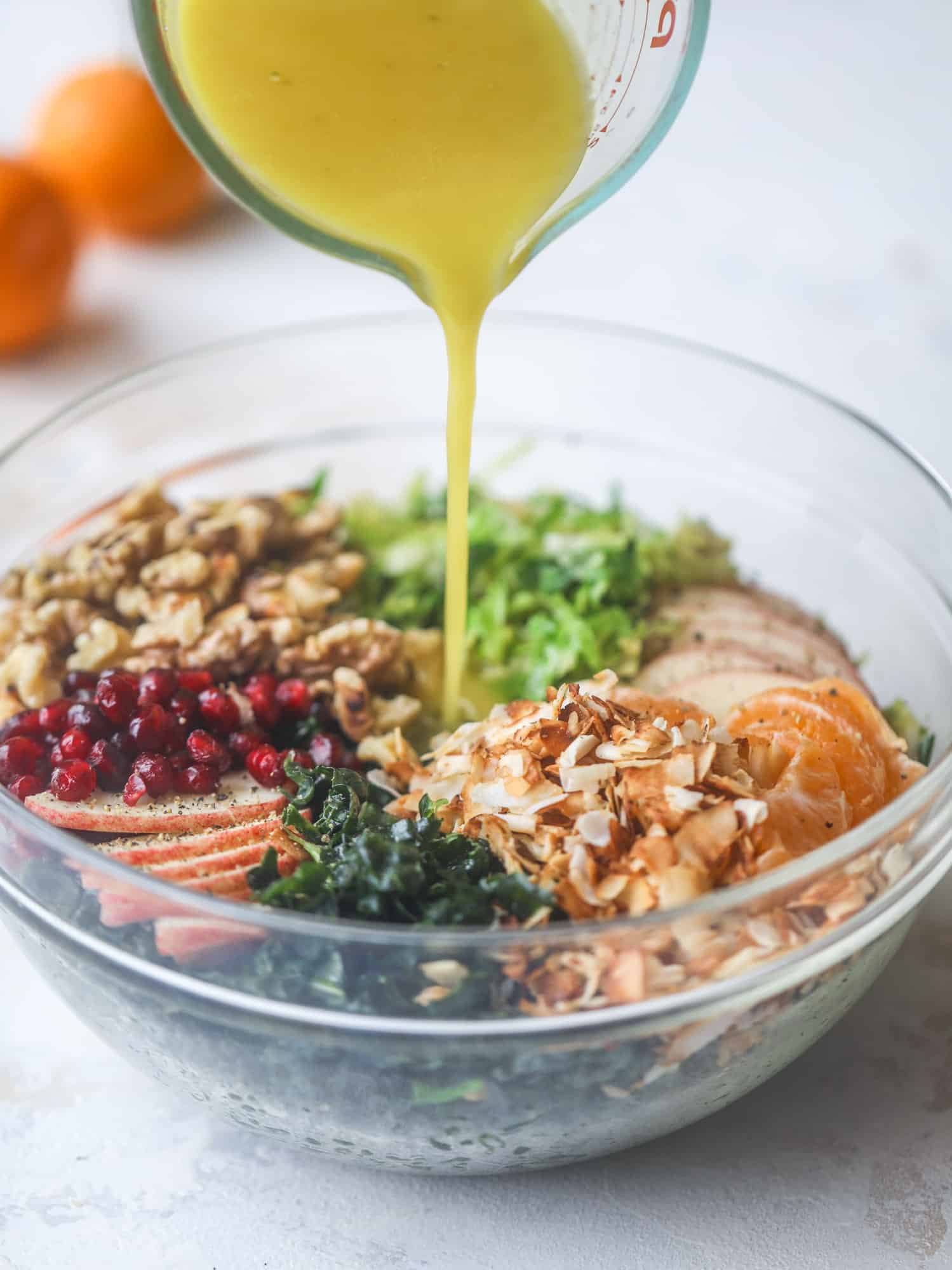 This winter crunch salad is loaded with tons of delicious, crunchy seasonal ingredients. A base of brussels sprouts and kale is topped with sliced apples, satsuma wedges, pomegranate arils, toasted walnuts and savory flaked coconut crunch. Delish! I howsweeteats.com #winter #salad