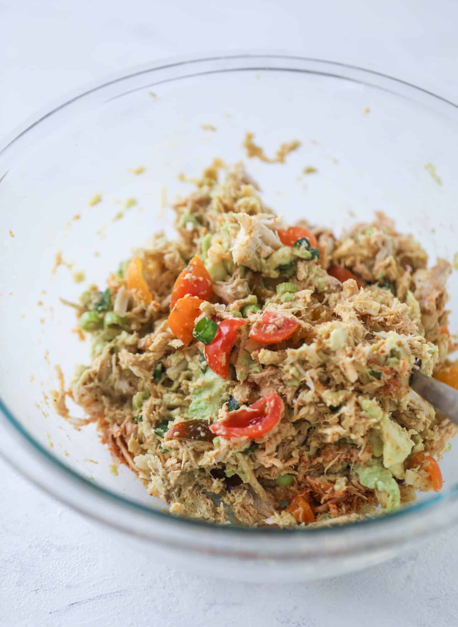 These baked avocados are stuffed with a cheesy chicken mixture and drizzled with sriracha yogurt sauce! Super delicious and an easy weeknight meal. I howsweeteats.com #baked #avocados