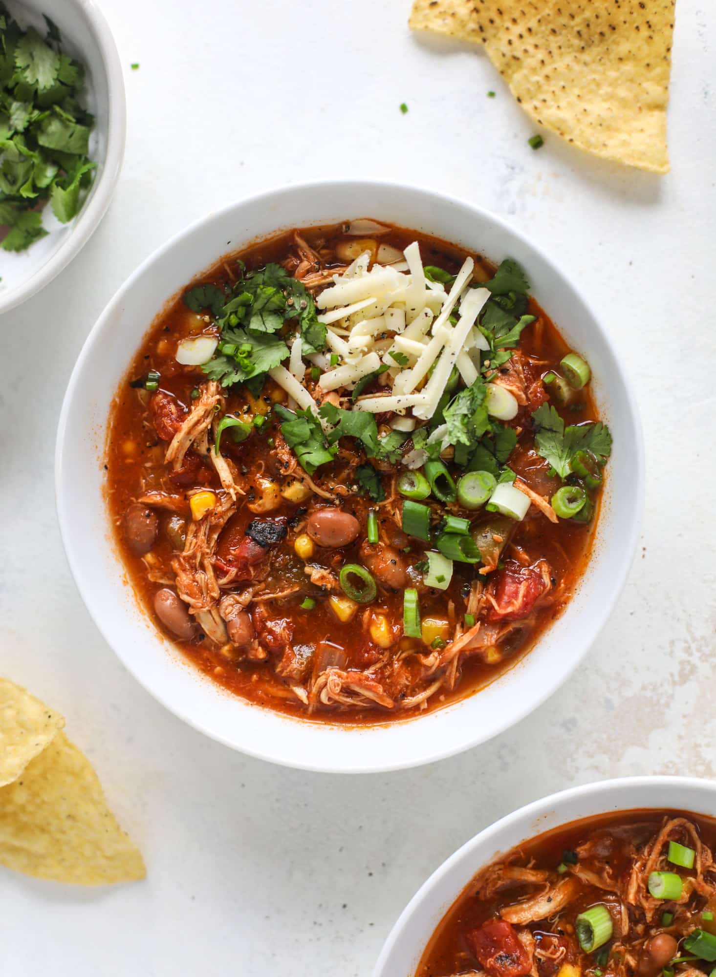 This flavorful chicken taco soup can be made on the stovetop or in the slow cooker. It's hearty and topped with cheese quesadilla croutons! I howsweeteats.com #chicken #tacosoup