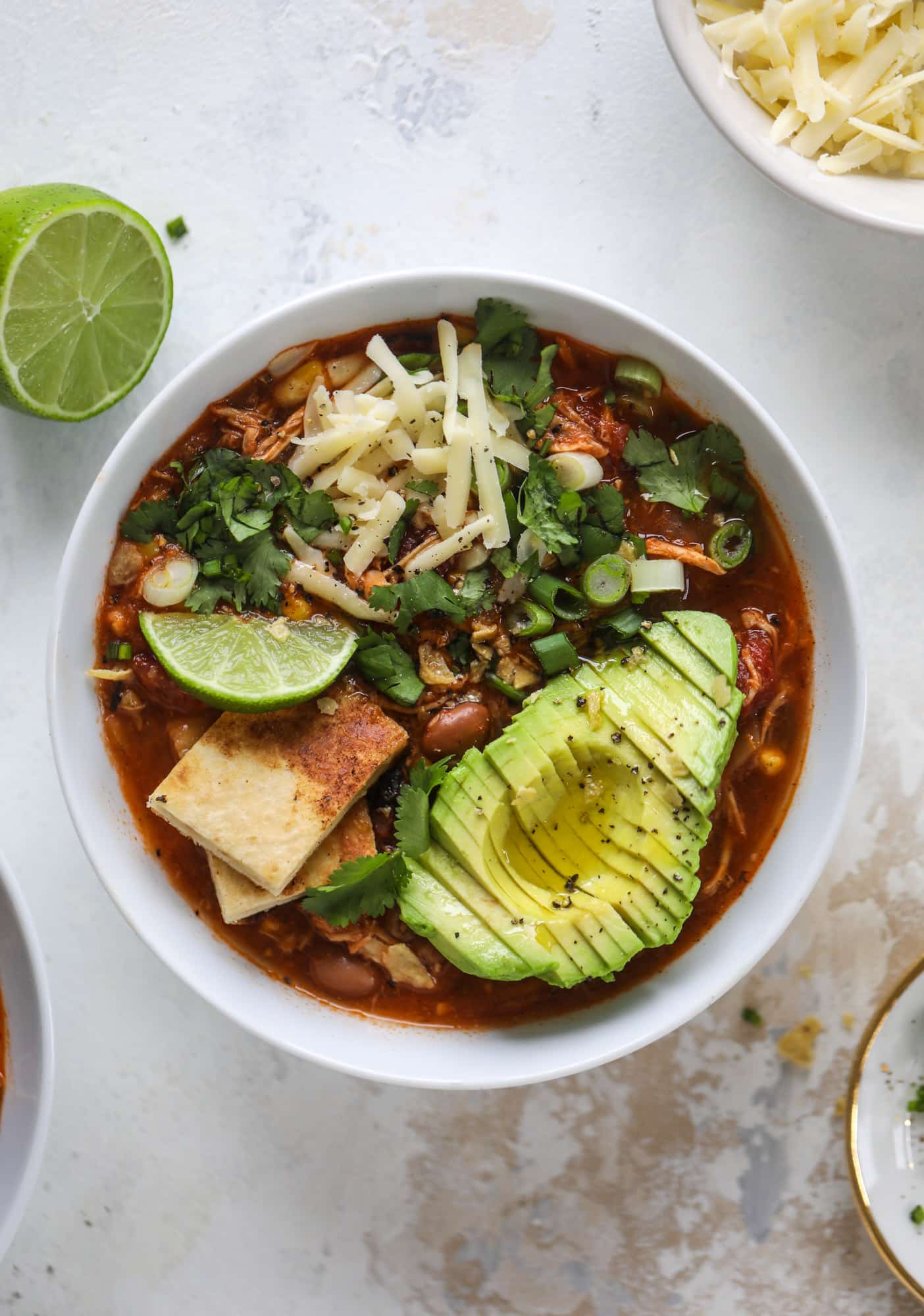 This flavorful chicken taco soup can be made on the stovetop or in the slow cooker. It's hearty and topped with cheese quesadilla croutons! I howsweeteats.com #chicken #tacosoup