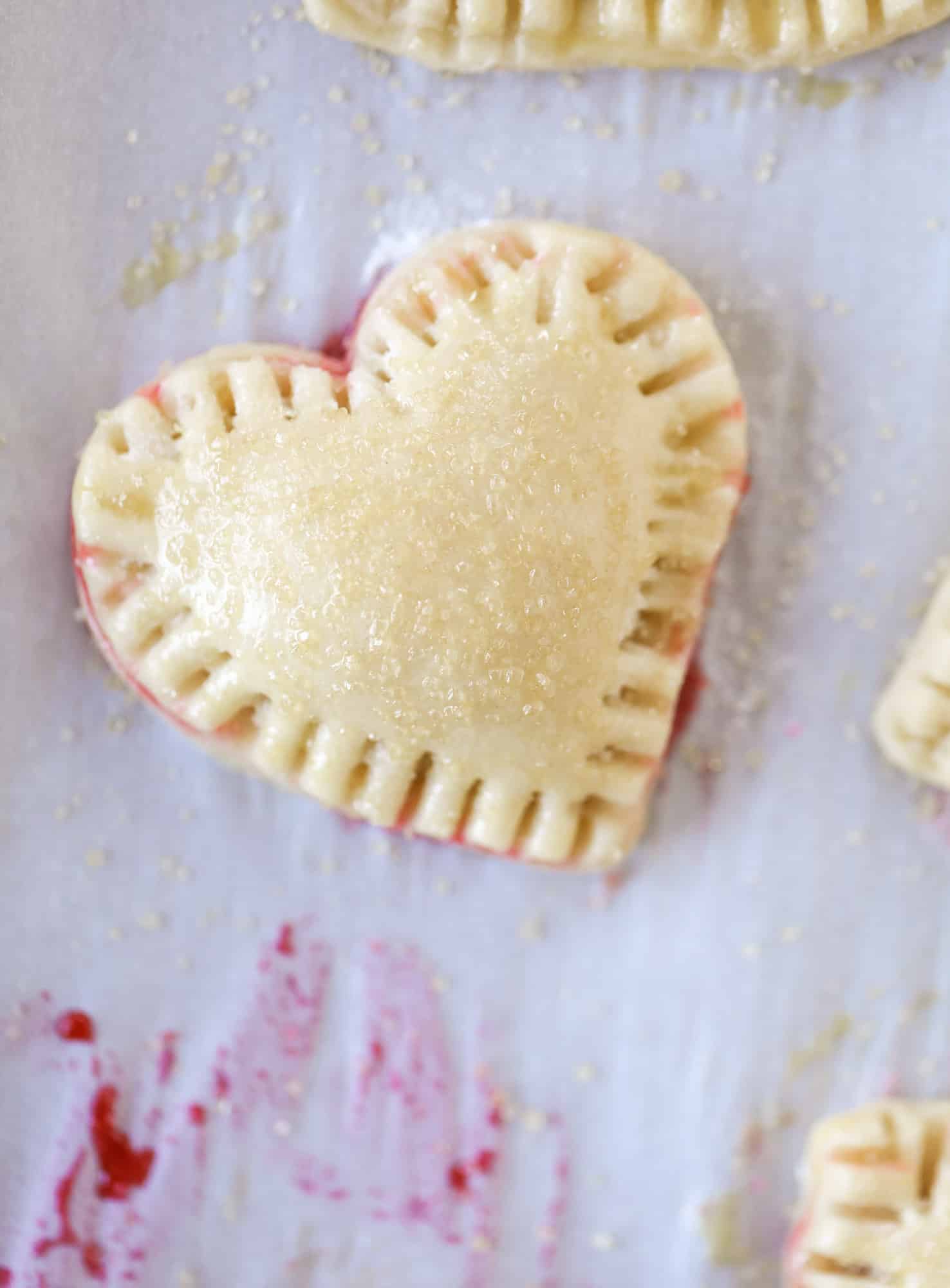 These adorable mini heart pies are filled with a homemade raspberry compote and creamy, chocolatey nutella. So fun and easy to make! I howsweeteats.com #heart #pie
