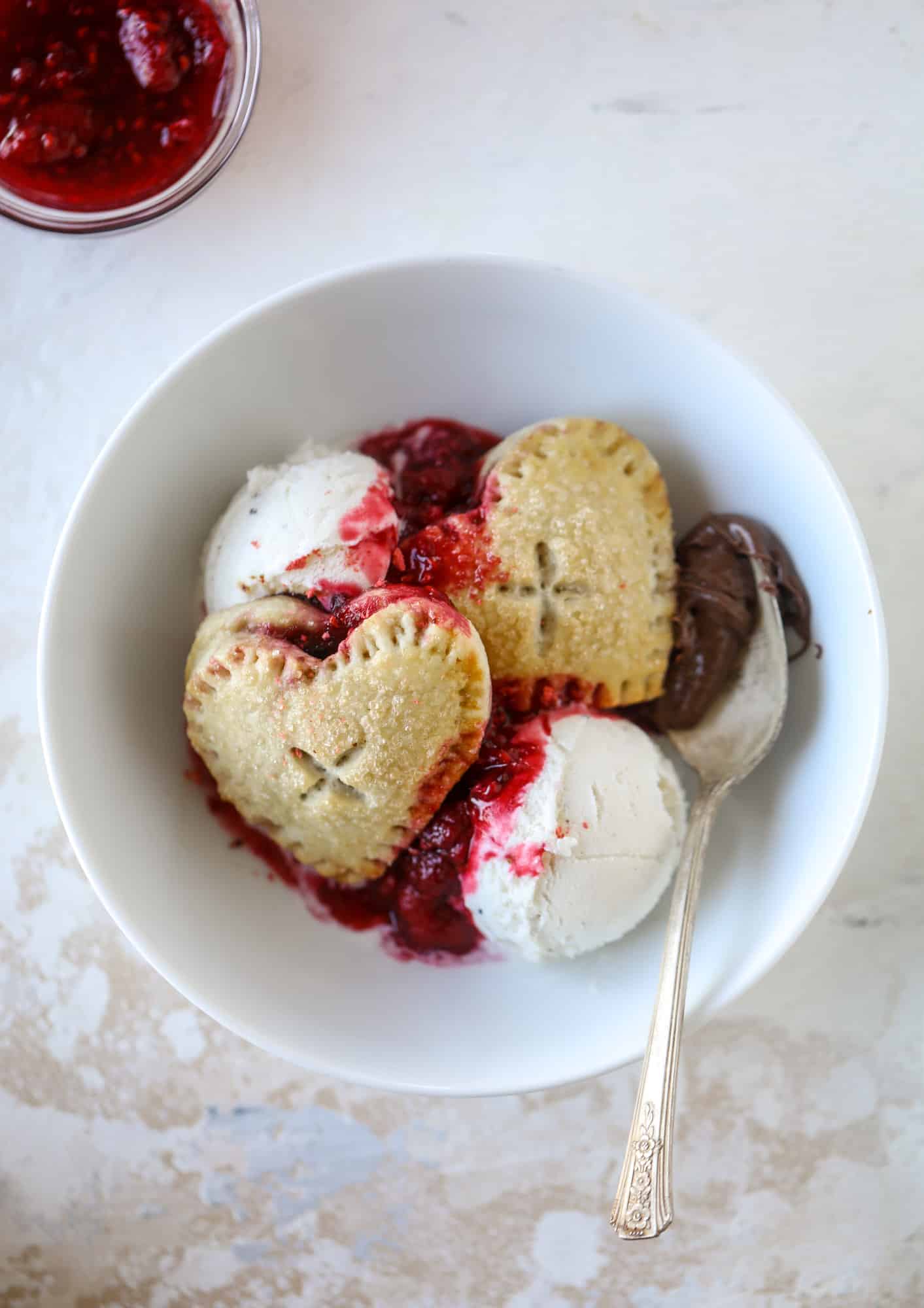 These adorable mini heart pies are filled with a homemade raspberry compote and creamy, chocolatey nutella. So fun and easy to make! I howsweeteats.com #heart #pie