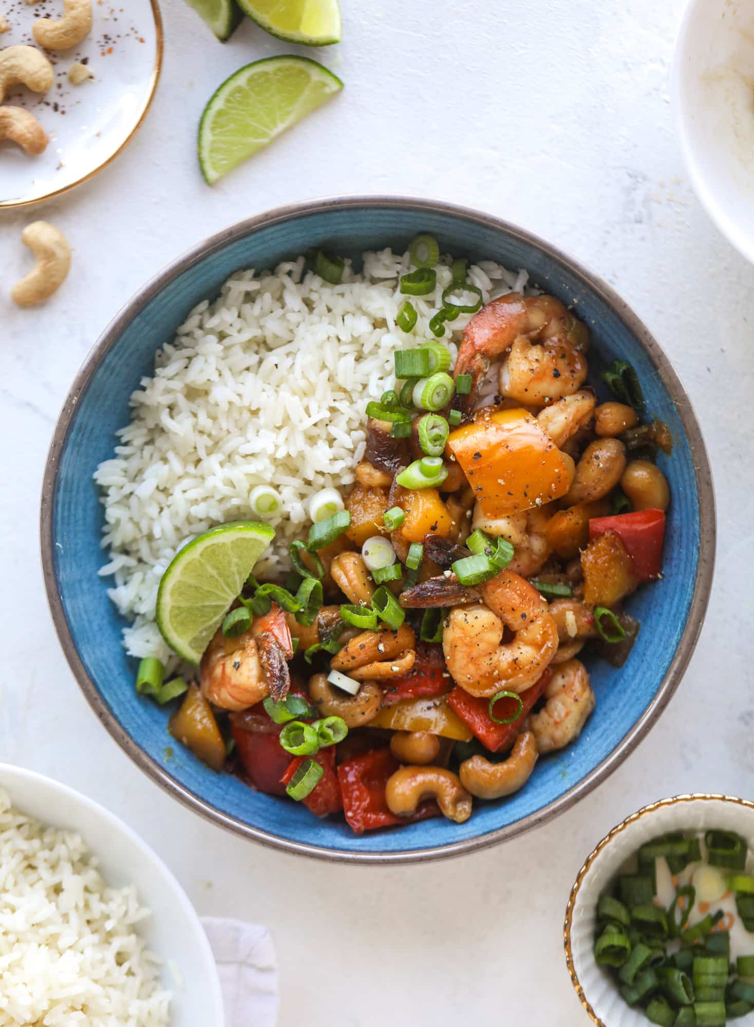 This cashew shrimp stir fry is a super simple weeknight meal! Made with bell peppers and mango, it is delicious over rice and comes together in 25 minutes. I howsweeteats.com #cashew #shrimp