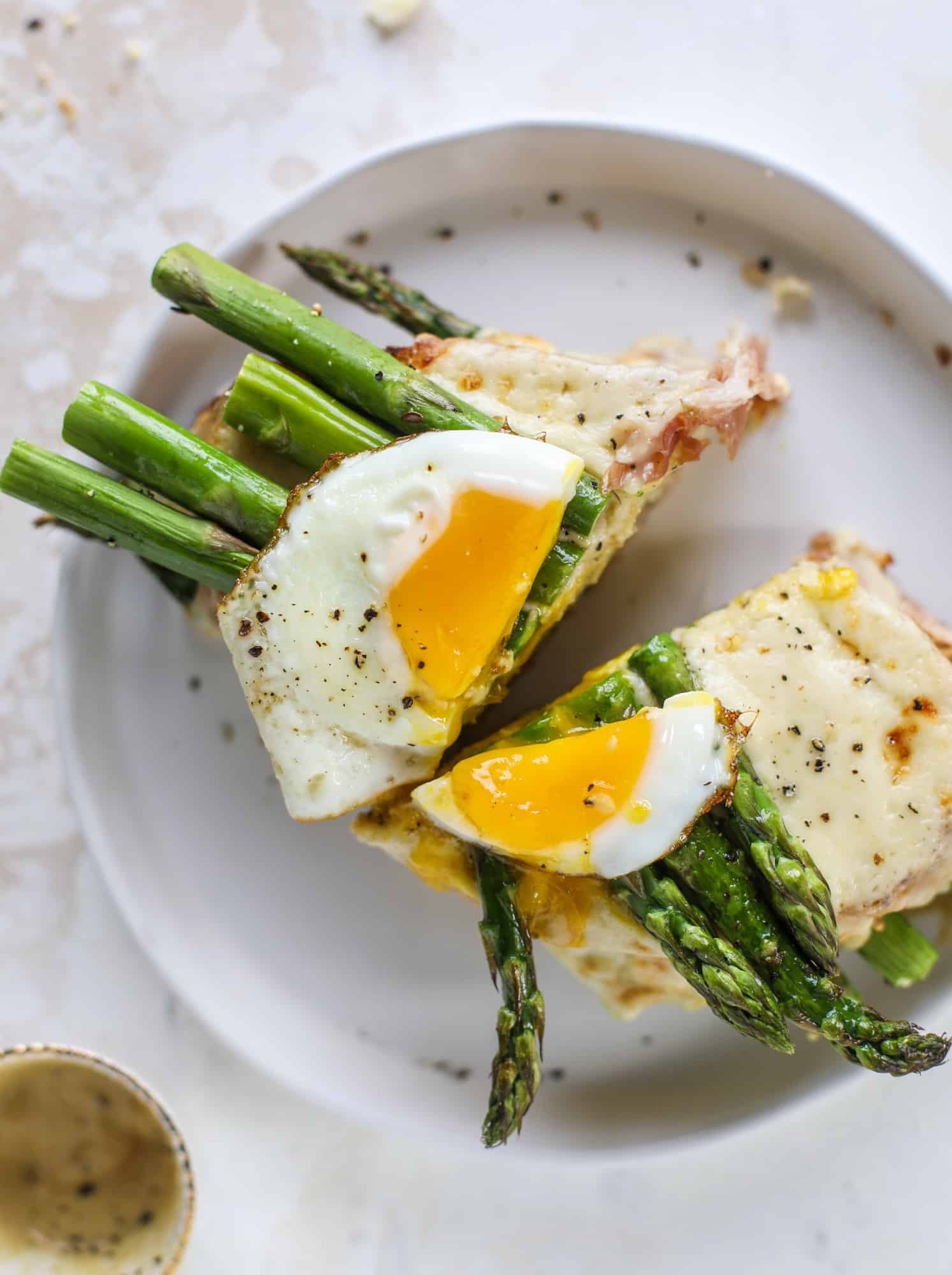 This roasted asparagus croque madame is made with thinly-sliced prosciutto and a fontina cheese sauce. Lots of dijon and an egg on top! I howsweeteats.com #croquemadame #asparagus