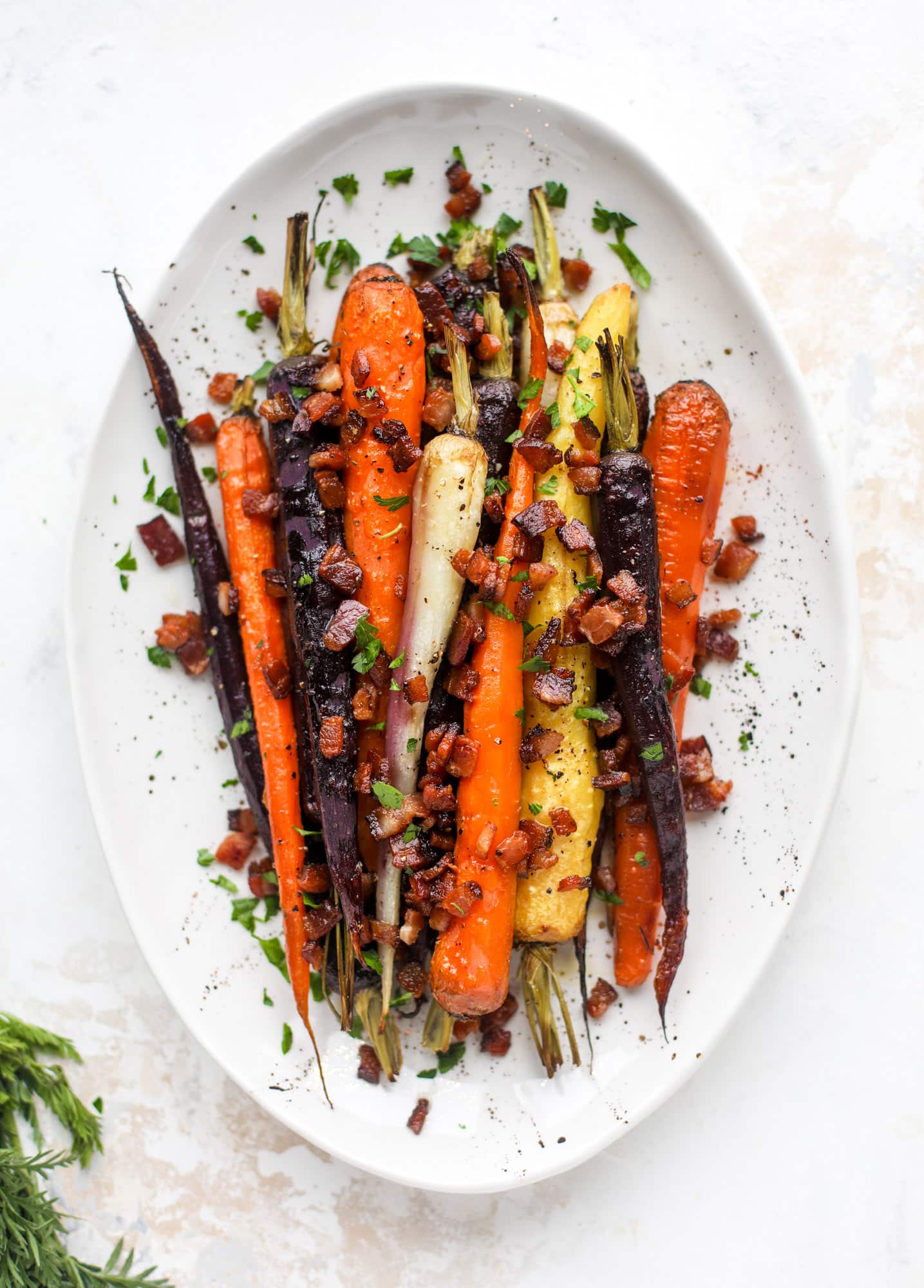 Sweet carrots are drizzled with bacon fat and chopped bacon, then roasted until they are tender, sweet and caramely. So much flavor!
