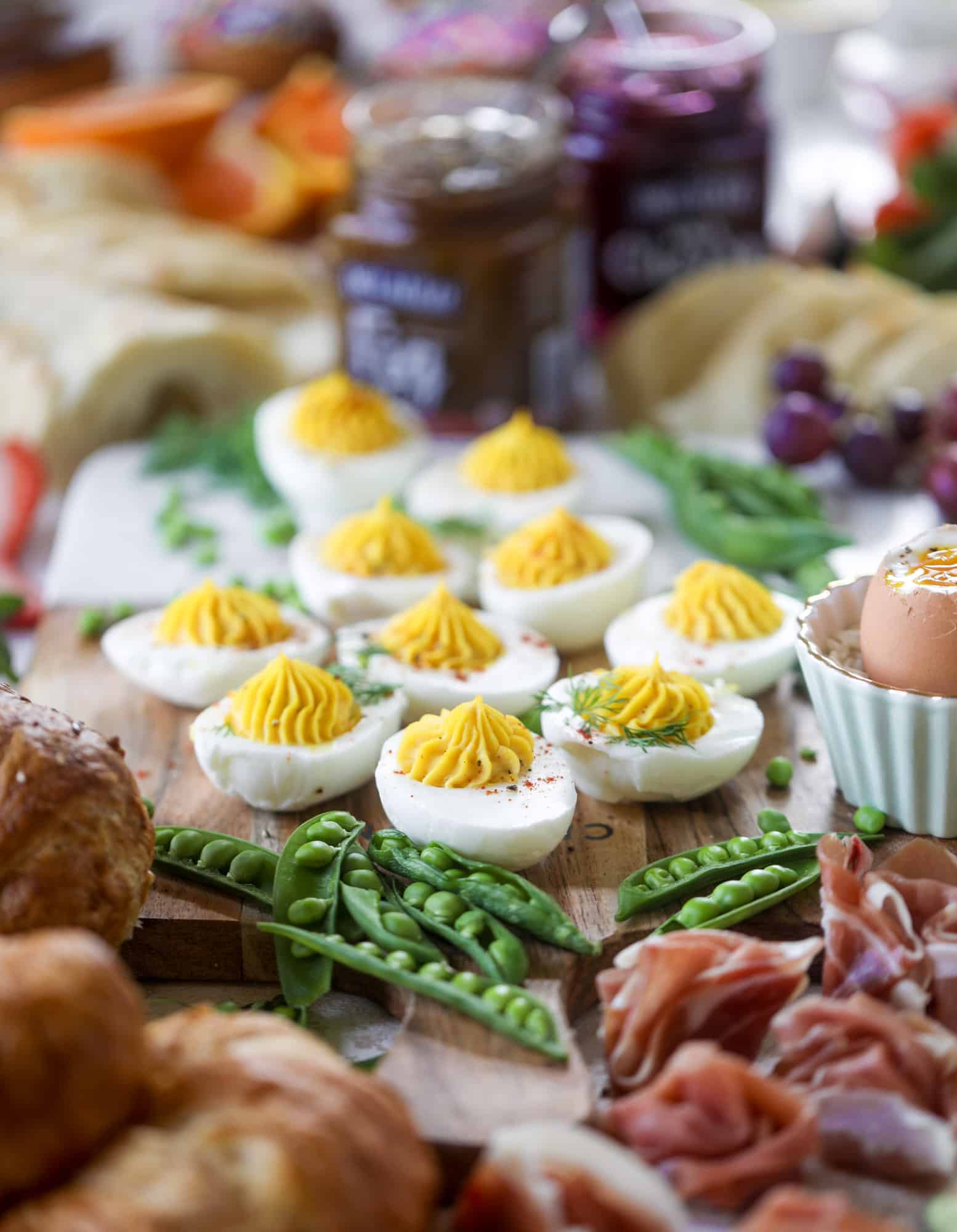 The highlight of this Easter brunch board are the deviled eggs and soft boiled eggs! Add some avocado toast, donuts and bloody marys and you've arrived. I howsweeteats.com #brunch #board