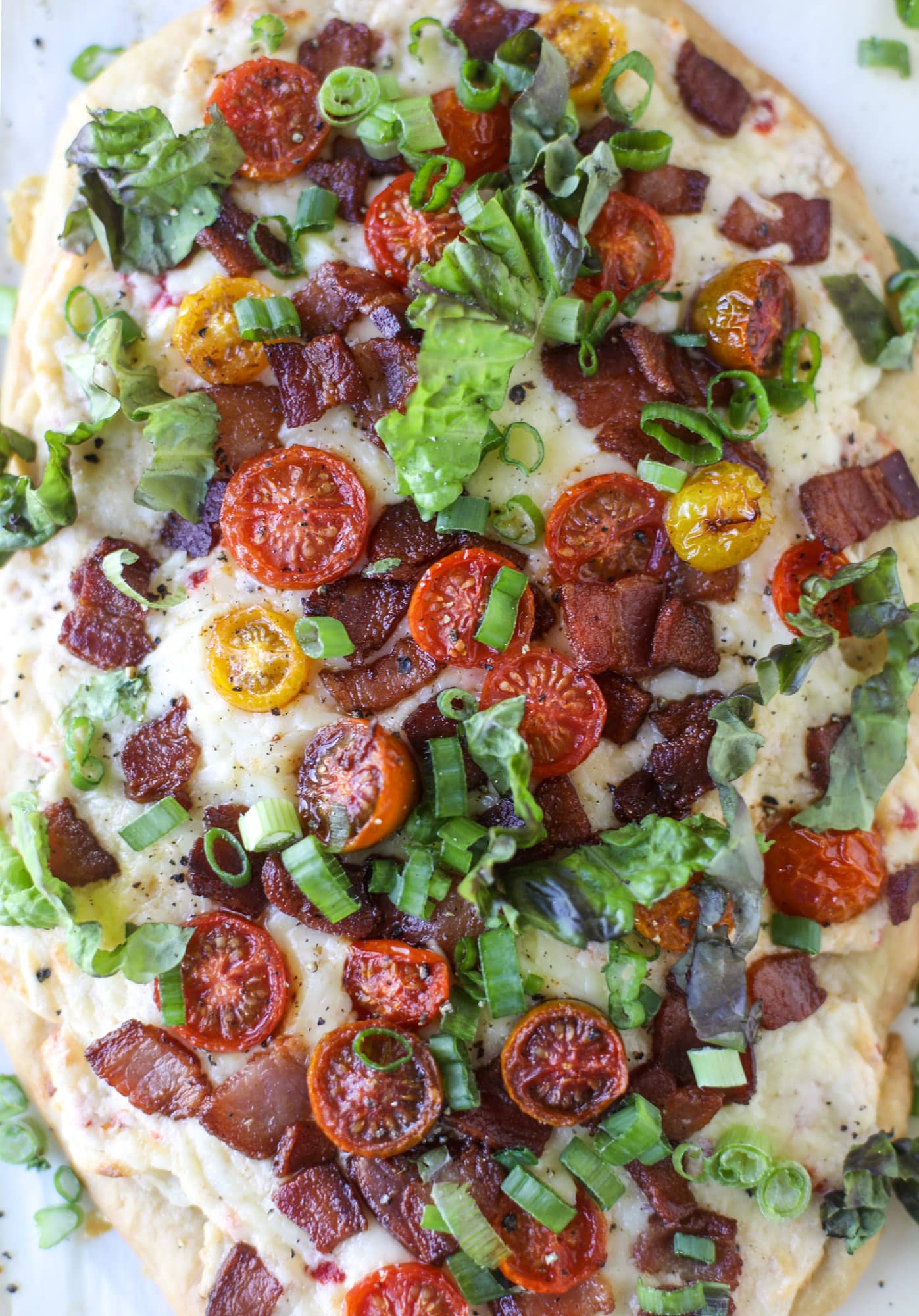 A crisped flatbread crust is topped with creamy pimento cheese, crispy bacon, garlic burst tomatoes and shredded lettuce. It's a flavor explosion!