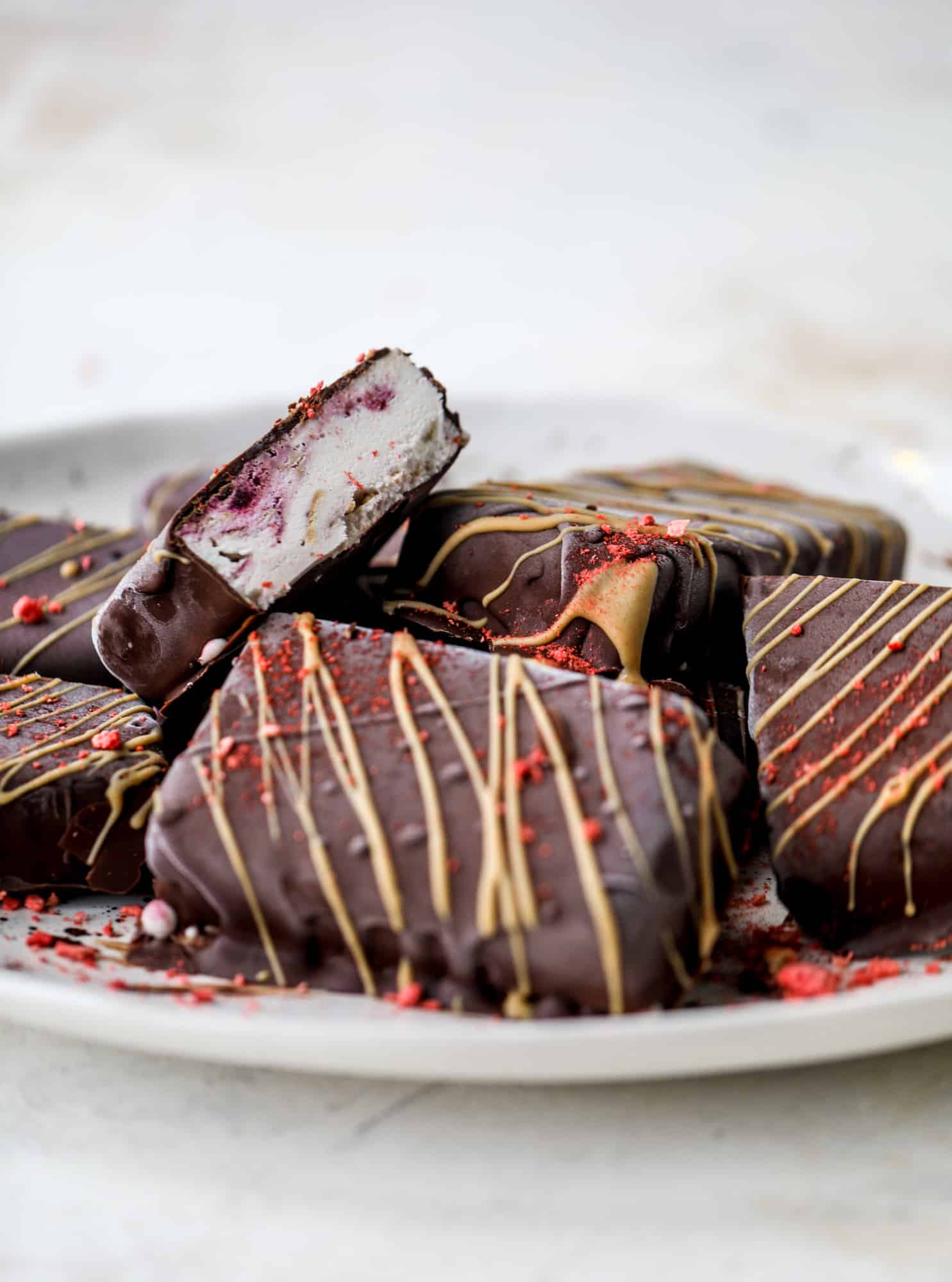 These frozen peanut butter jelly bars are super easy and made with an oatmilk frozen dessert, then covered in a dark chocolate shell. Delish! 