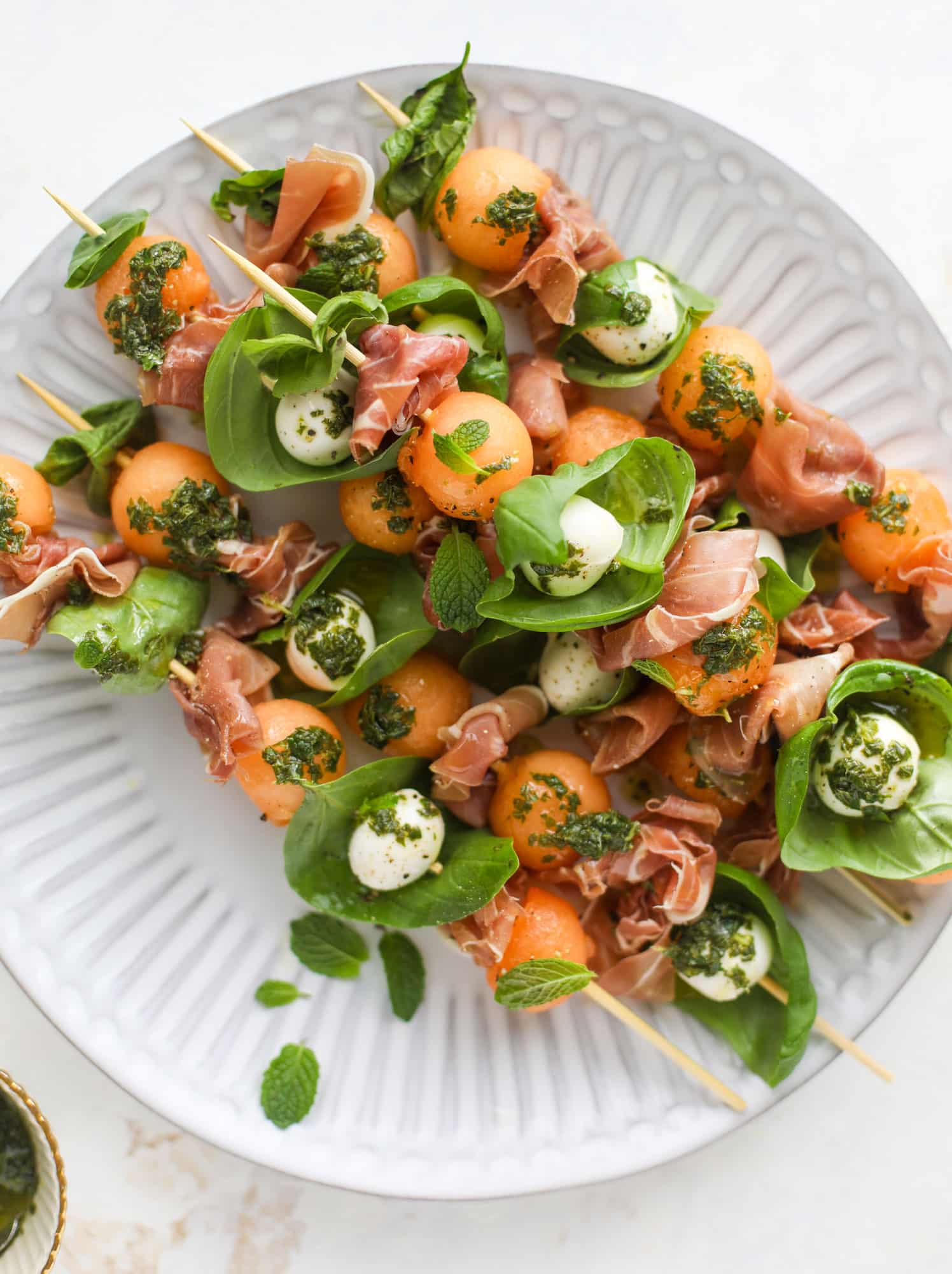 These cantaloupe prosciutto skewers are the perfect cantoloupe caprese snack! Salty prosciutto, sweet melon and fresh mozzarella drizzled with mint pesto!
