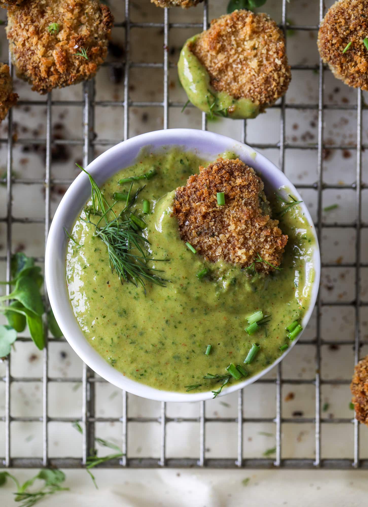 Oven fried crispy pickles are super crunchy and delicious! Served with a dairy free green goddess ranch dip, they are the best snack ever. 