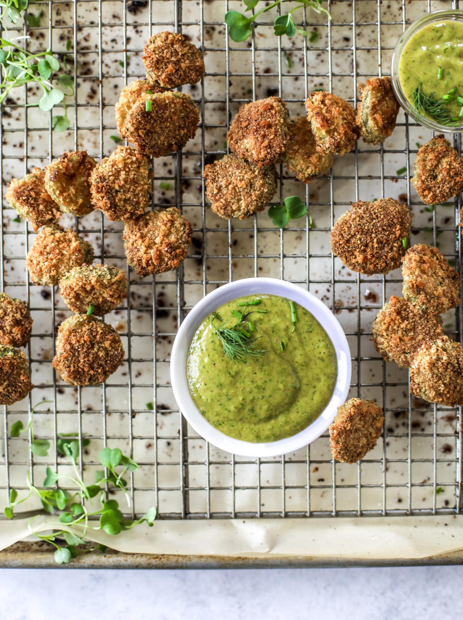 Oven fried crispy pickles are super crunchy and delicious! Served with a dairy free green goddess ranch dip, they are the best snack ever. 