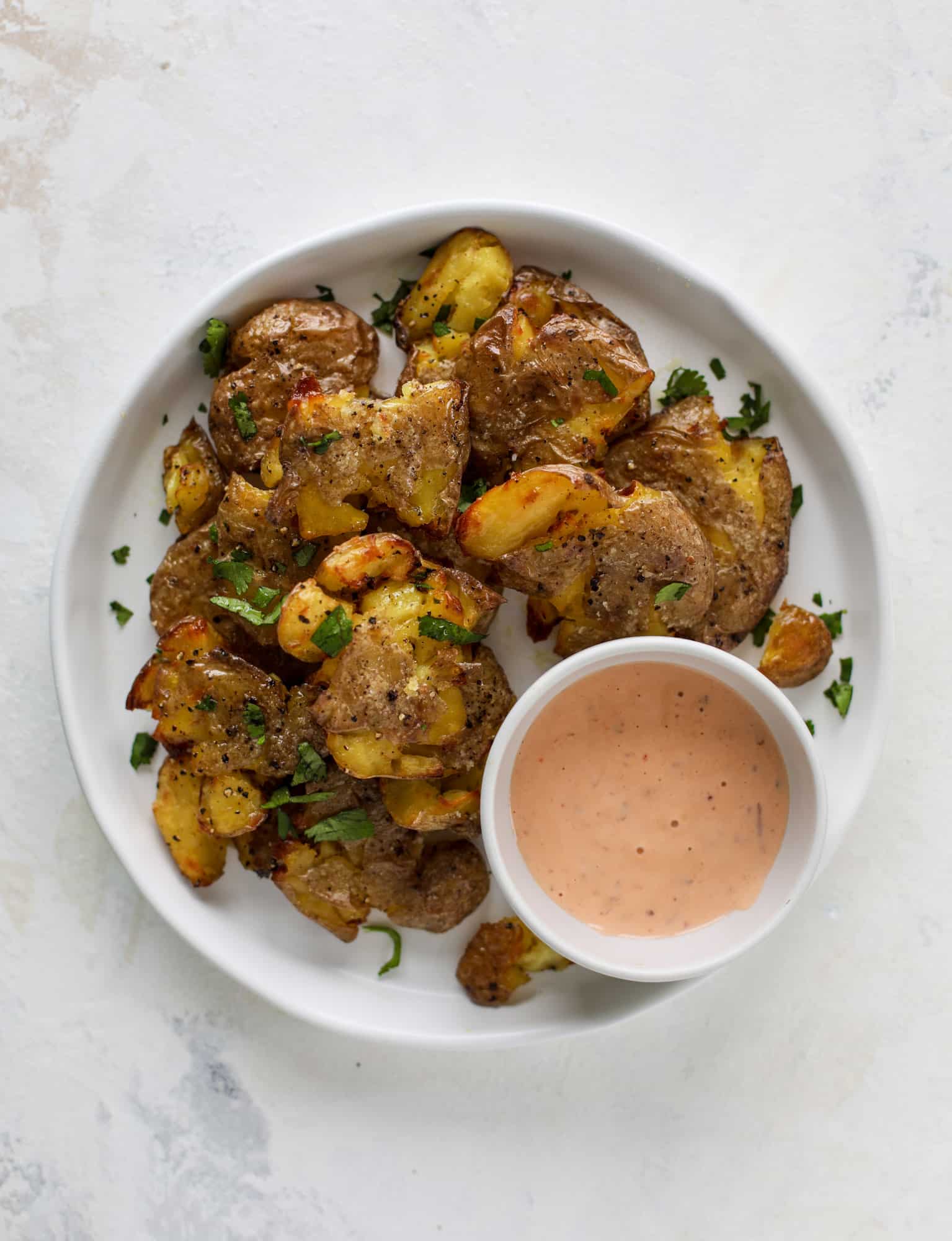 This is our favorite side dish ever! Crispy smashed potatoes roasted in the oven to perfection. Serve them with a dipping sauce or as a side dish!