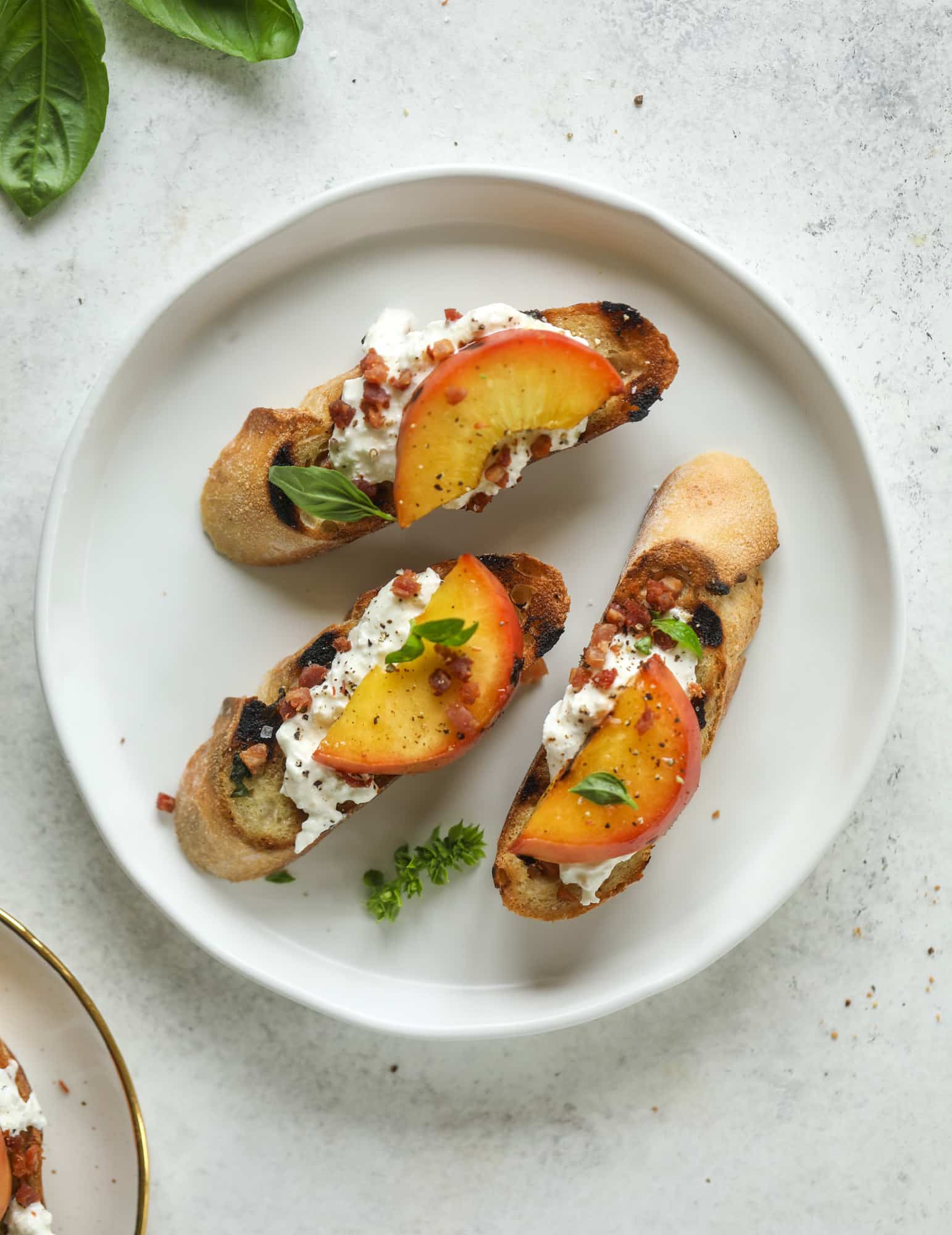 This peach burrata crostini is the best summer appetizer! it starts with grilled basil butter toasts that are topped with burrata, peach and pancetta!