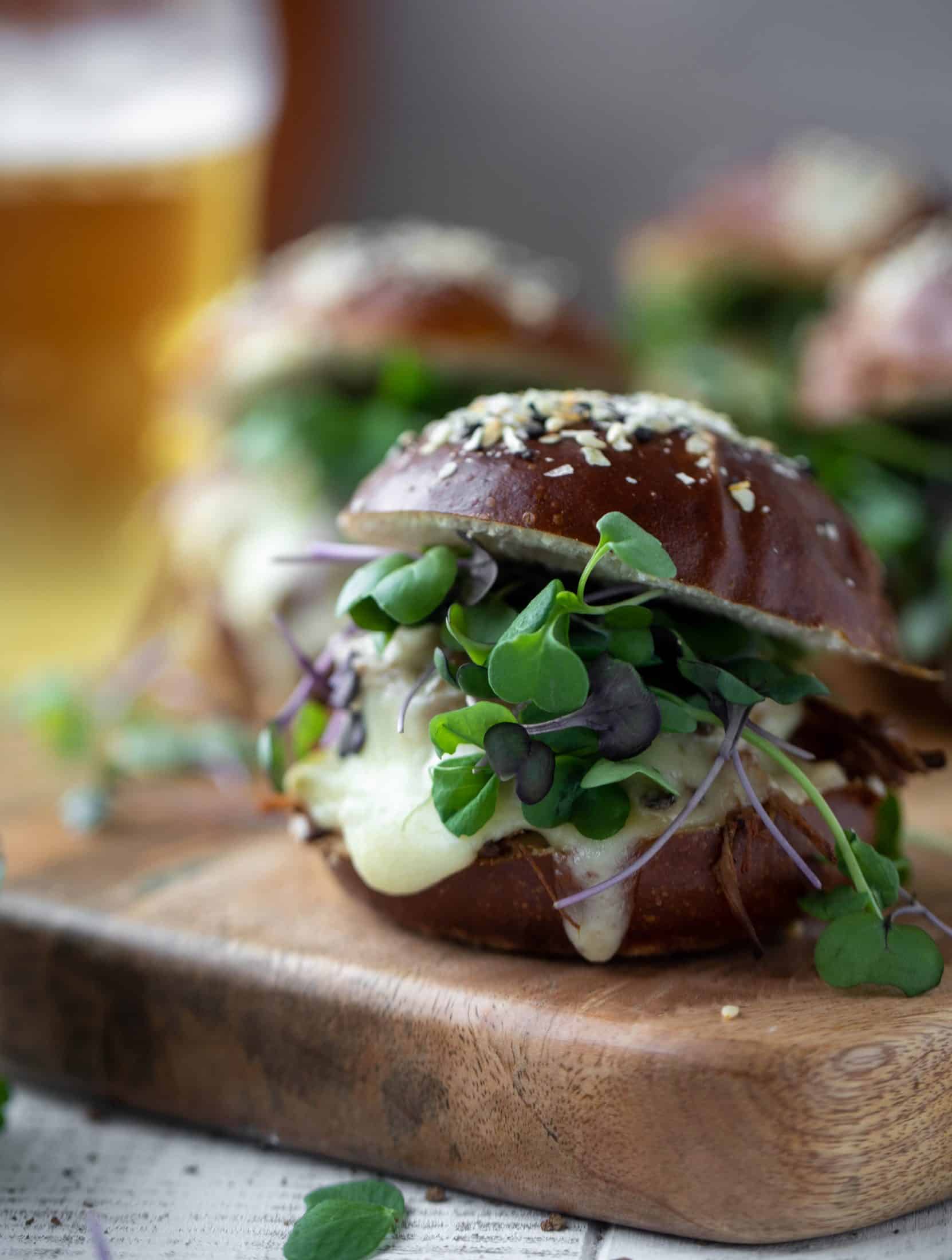This pumpkin beer brisket melts are smothered in havarti cheese and served on everything pretzel rolls. They are ridiculously delicious!