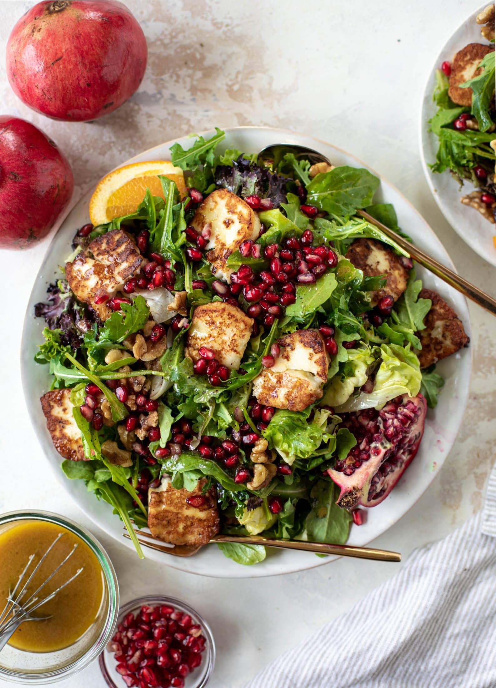 A pomegranate halloumi salad that's the perfect starter to your holiday meal! Drizzle with a spiced orange vinaigrette for the most festive flavor ever.