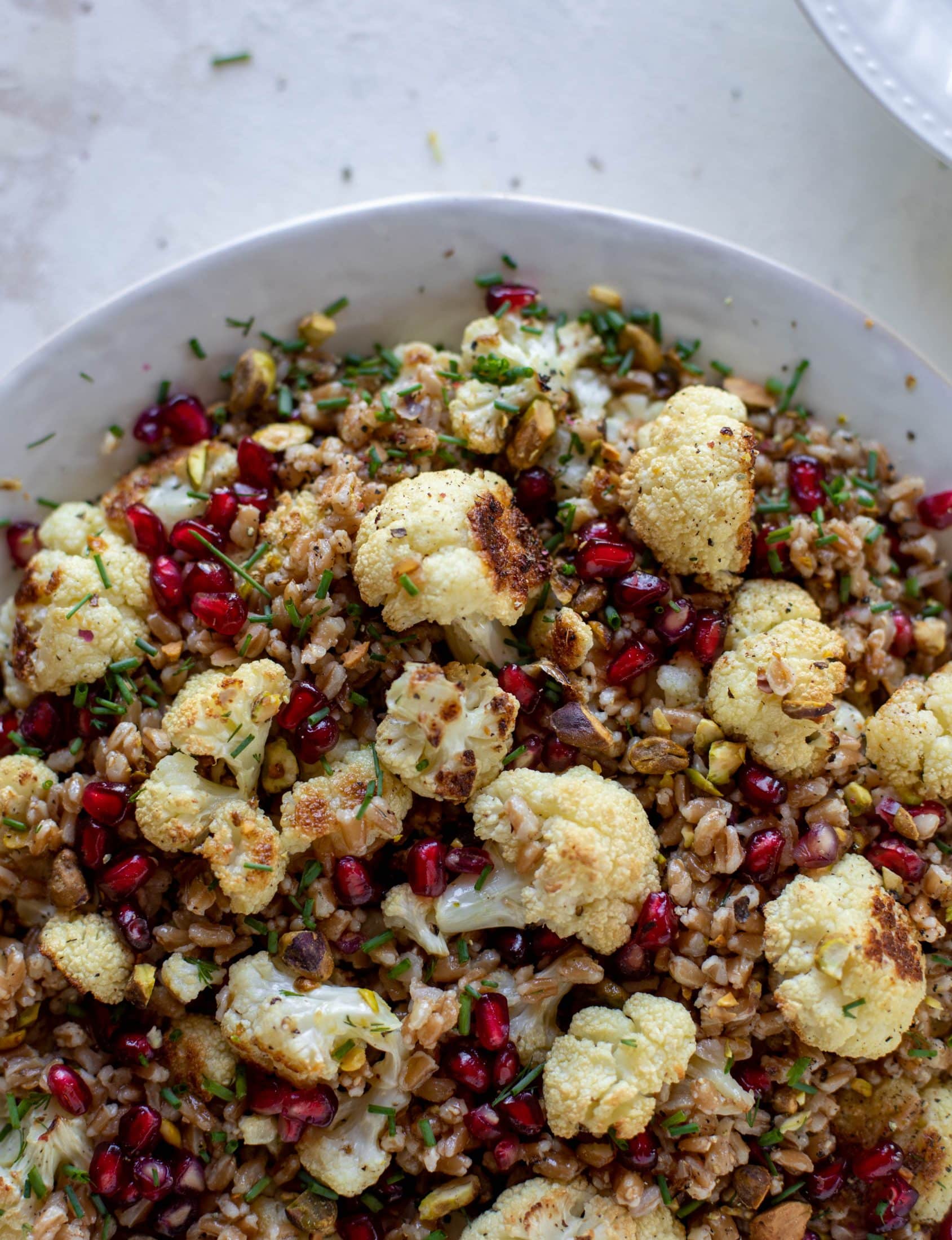 This cauliflower farro salad is filled with roasted cauliflower, pistachios, pomegranates and drizzled with a dill vinaigrette. Delicious!