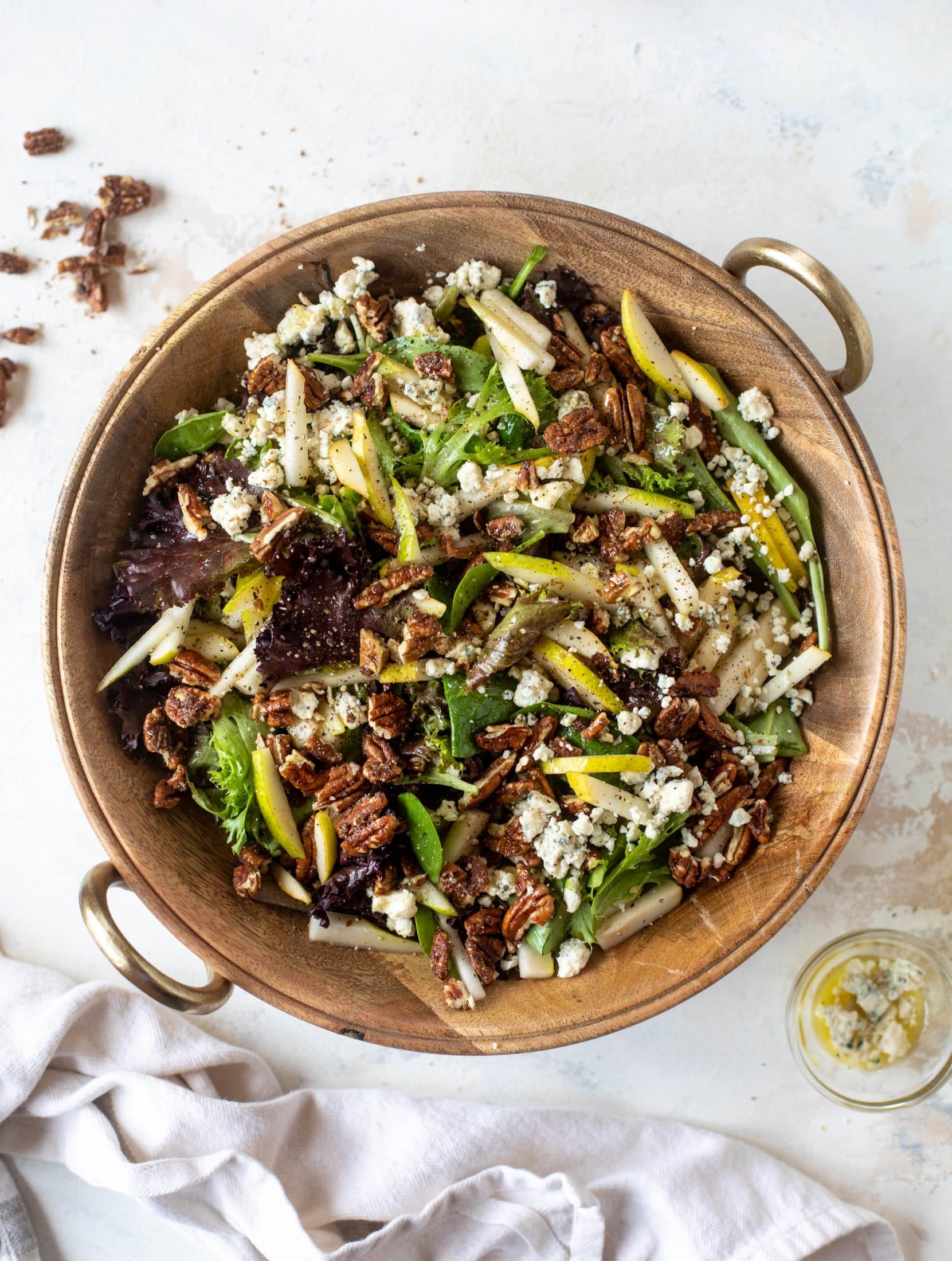 This pear gorgonzola is the perfect simple greens salad for the holiday and winter season! Topped with sweet and spicy pecans and champagne vinaigrette!