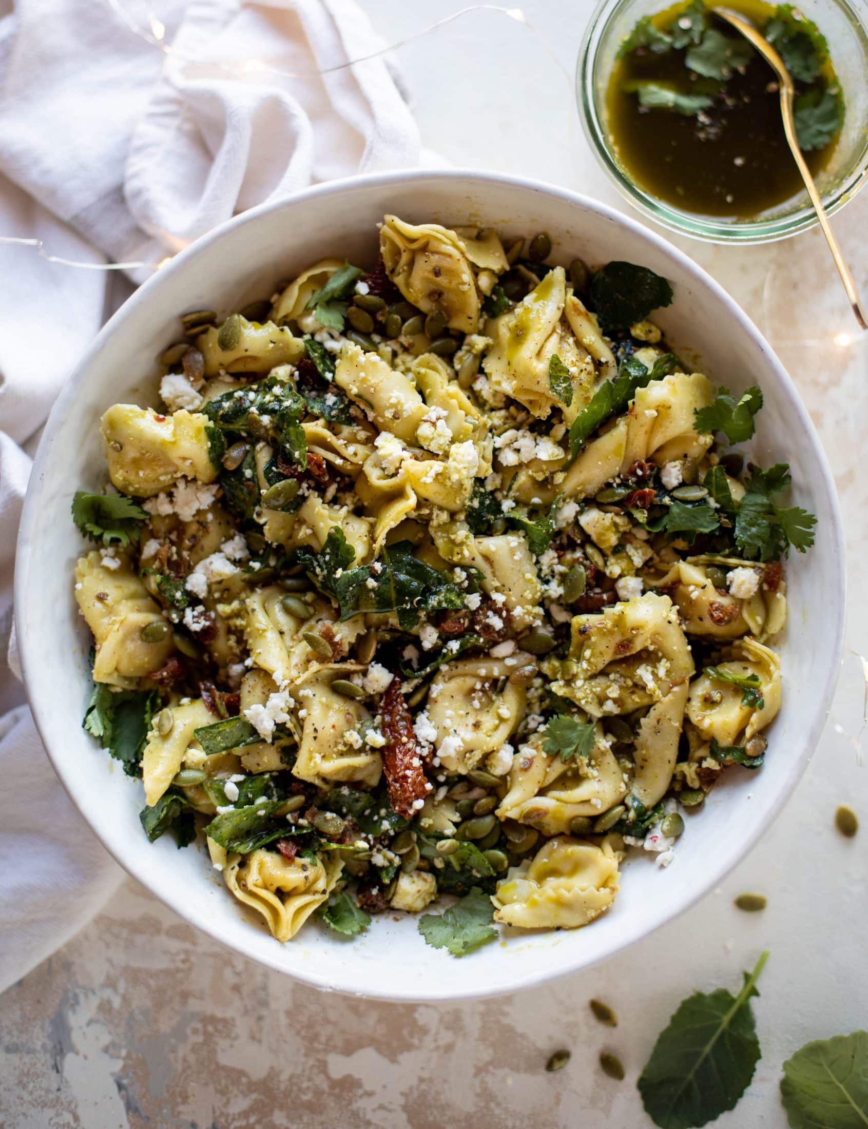 This cilantro lime tortellini salad is loaded with flavor! Served warm or cold, it has pepitas, sun dried tomatoes and crumbled feta. It's ridiculously good! 