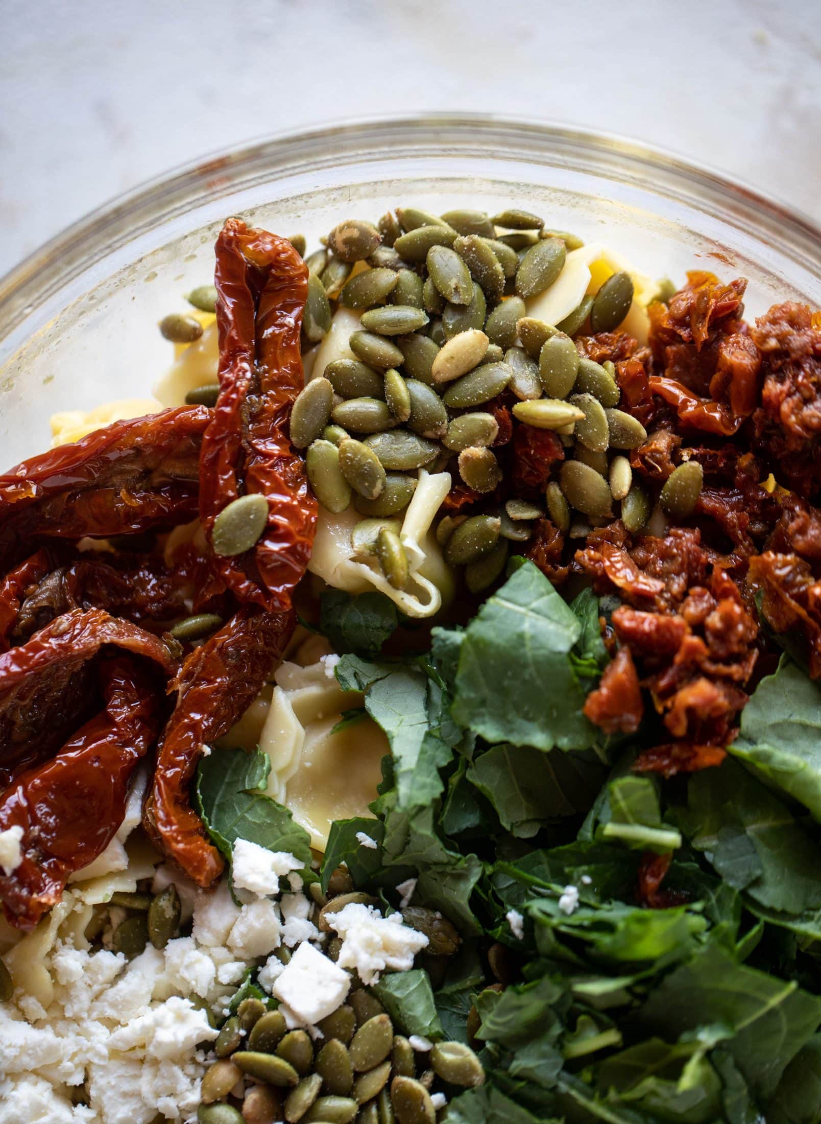 This cilantro lime tortellini salad is loaded with flavor! Served warm or cold, it has pepitas, sun dried tomatoes and crumbled feta. It's ridiculously good! 