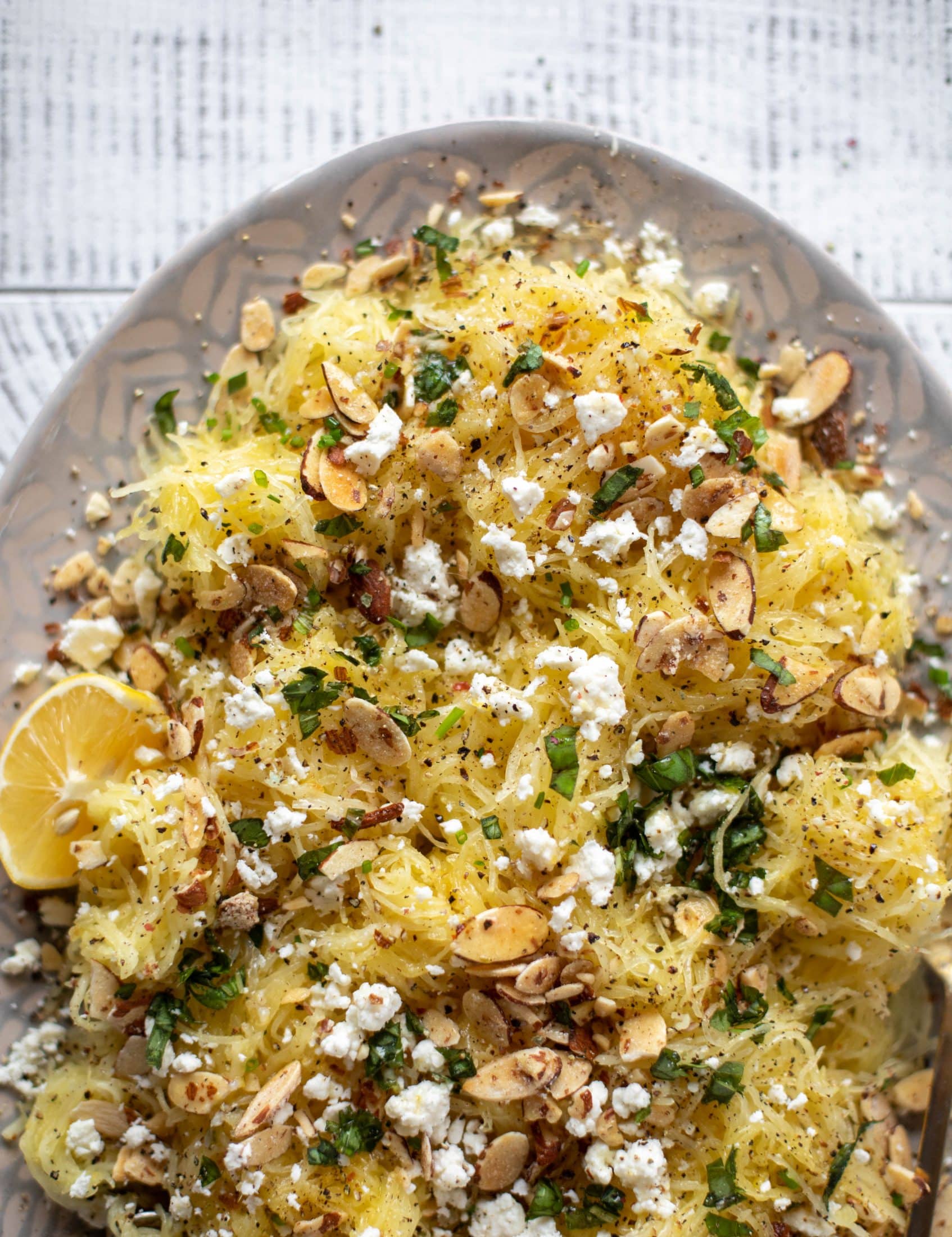 This lemon spaghetti squash is tossed in a lemon garlic butter and topped with feta, sliced toasted almonds and fresh herbs. It's delicious! 