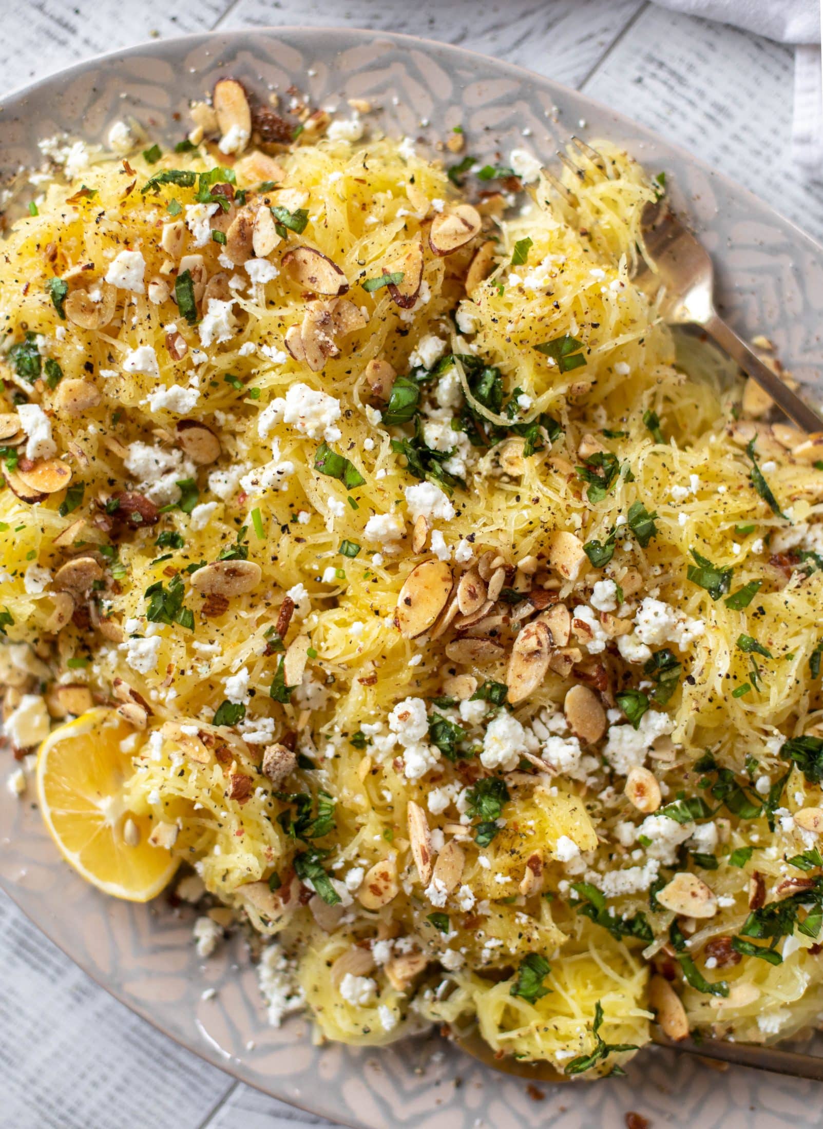 This lemon spaghetti squash is tossed in a lemon garlic butter and topped with feta, sliced toasted almonds and fresh herbs. It's delicious! 