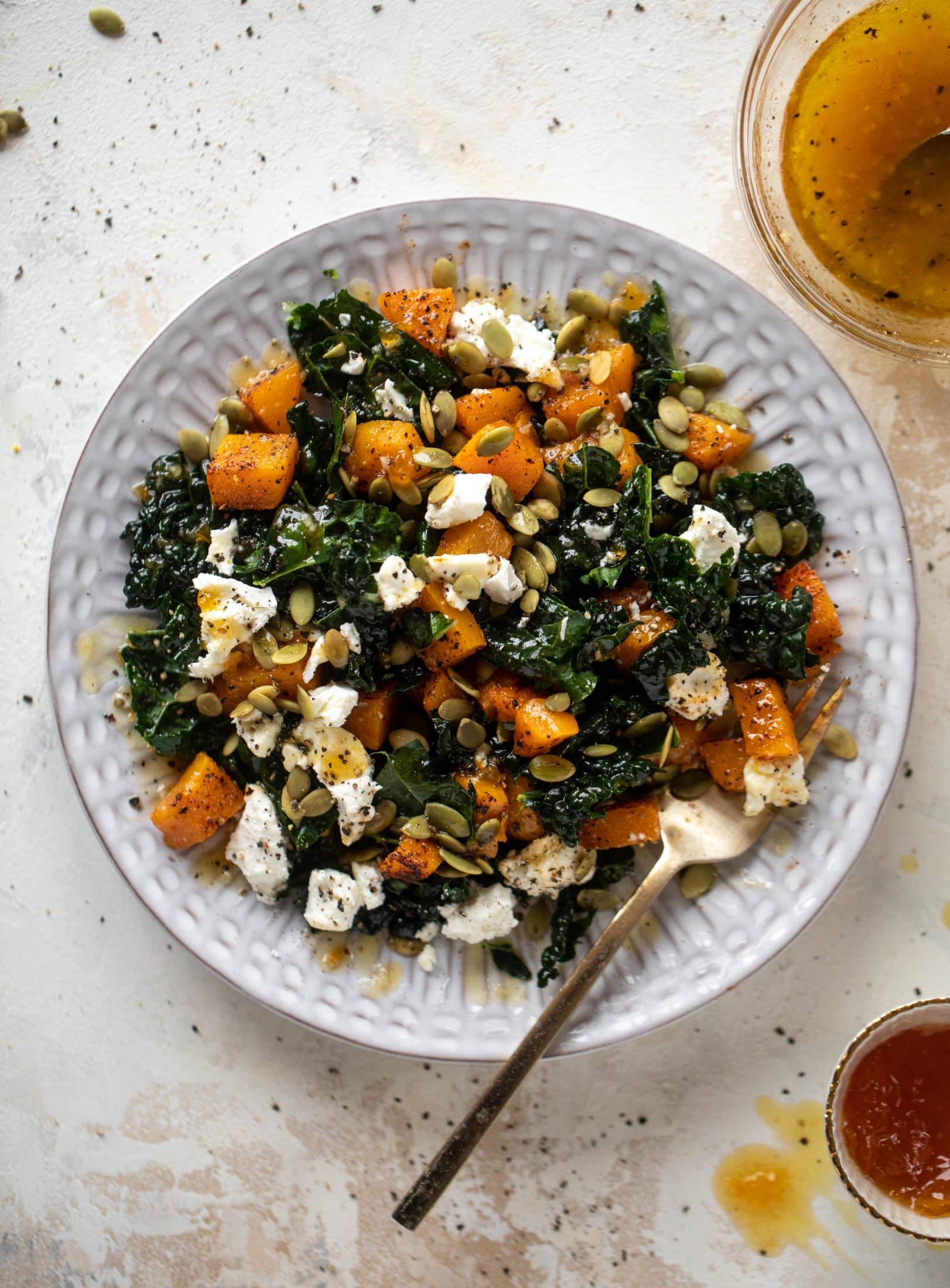 This butternut squash kale salad is so easy and delicious! Roasted, smoky butternut squash, goat cheese, pepitas and apricot vinaigrette.