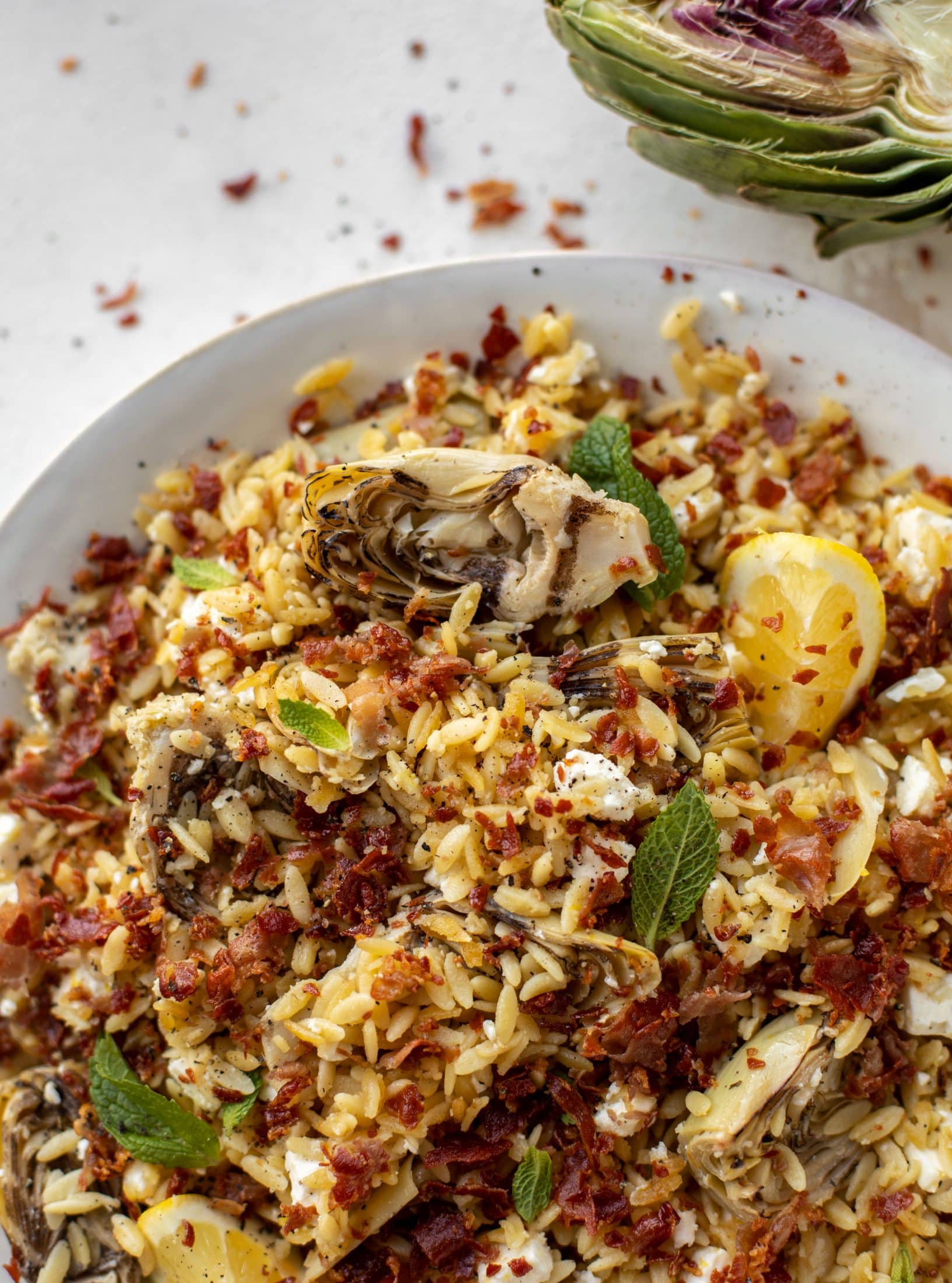 This crispy orzo is a wonderful spring dish. Artichoke hearts, lemon, goat cheese and herbs all topped with a sprinkling of crunchy prosciutto. 