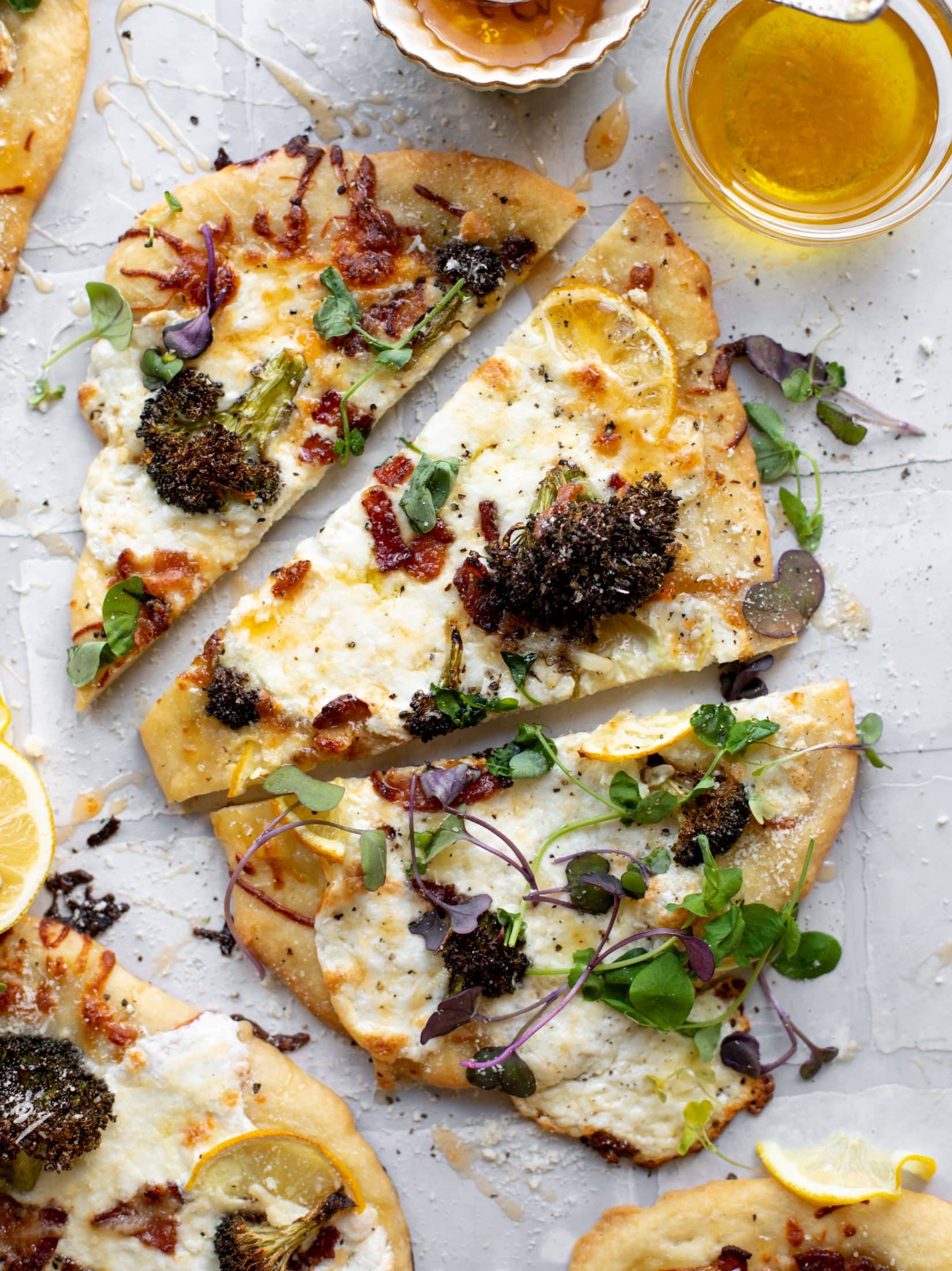 This cheesy lemon flatbread pizza is covered with burrata cheese, parmesan, roasted vegetables and hot honey. It's a flavor dream!