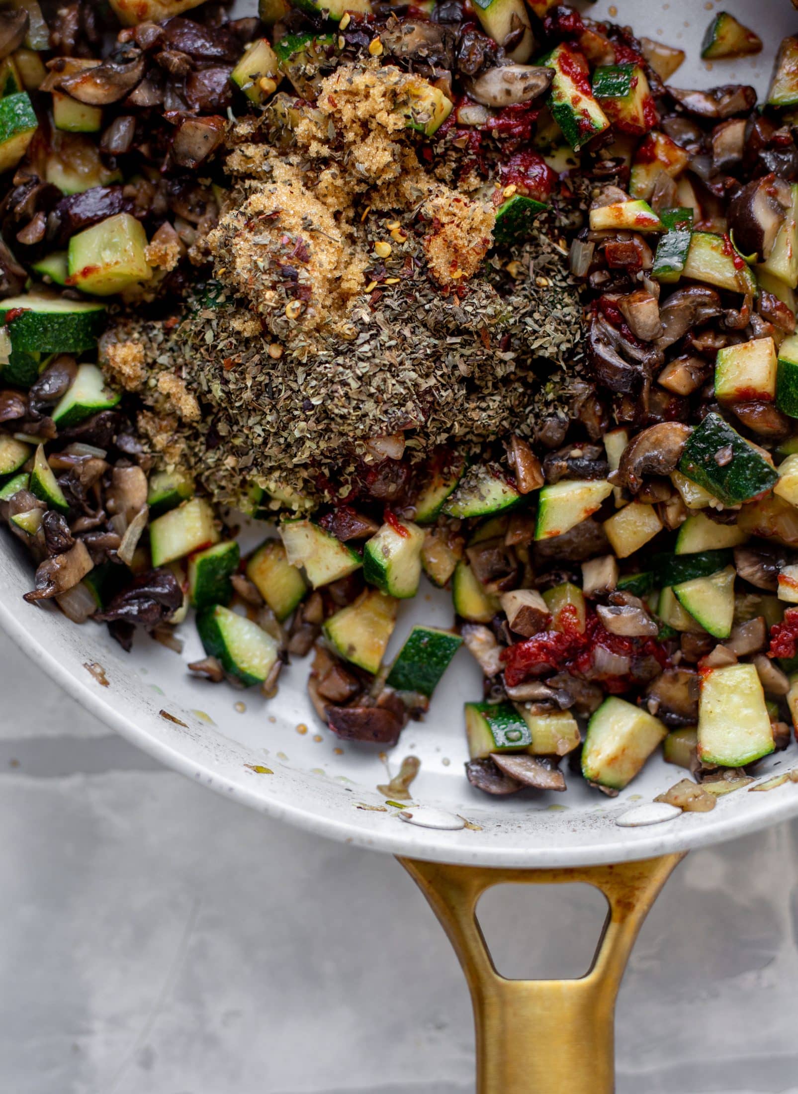 spices with zucchini and mushrooms in a skillet