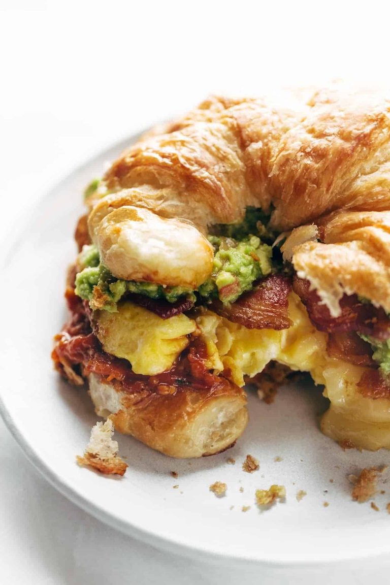 Croissant breakfast sandwich on a plate.