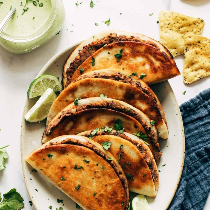 Crispy black bean tacos on a plate.