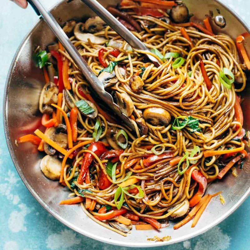 Lo Mein in pan with tongs.