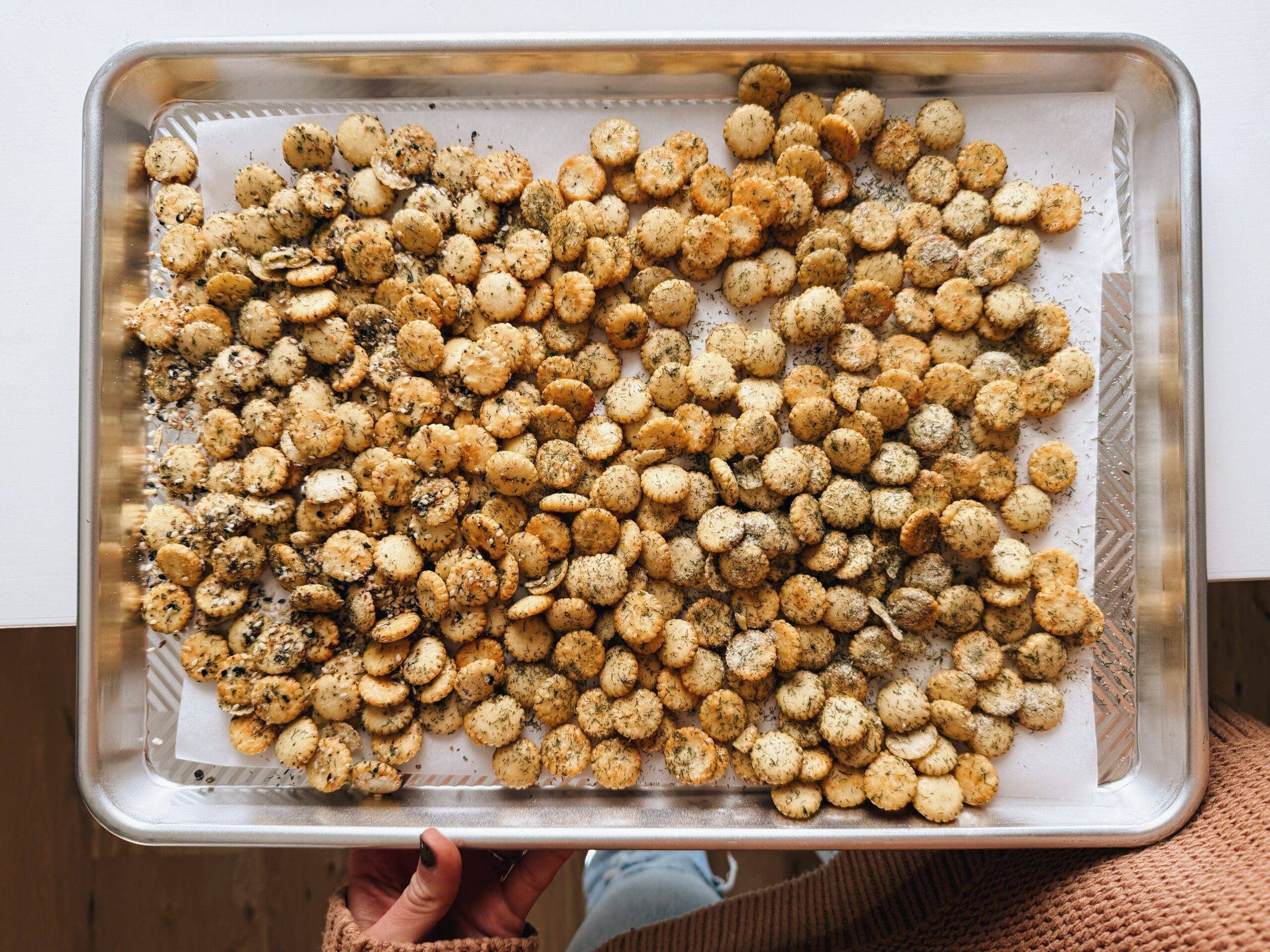 Ranch crackers spread on a sheet pan.