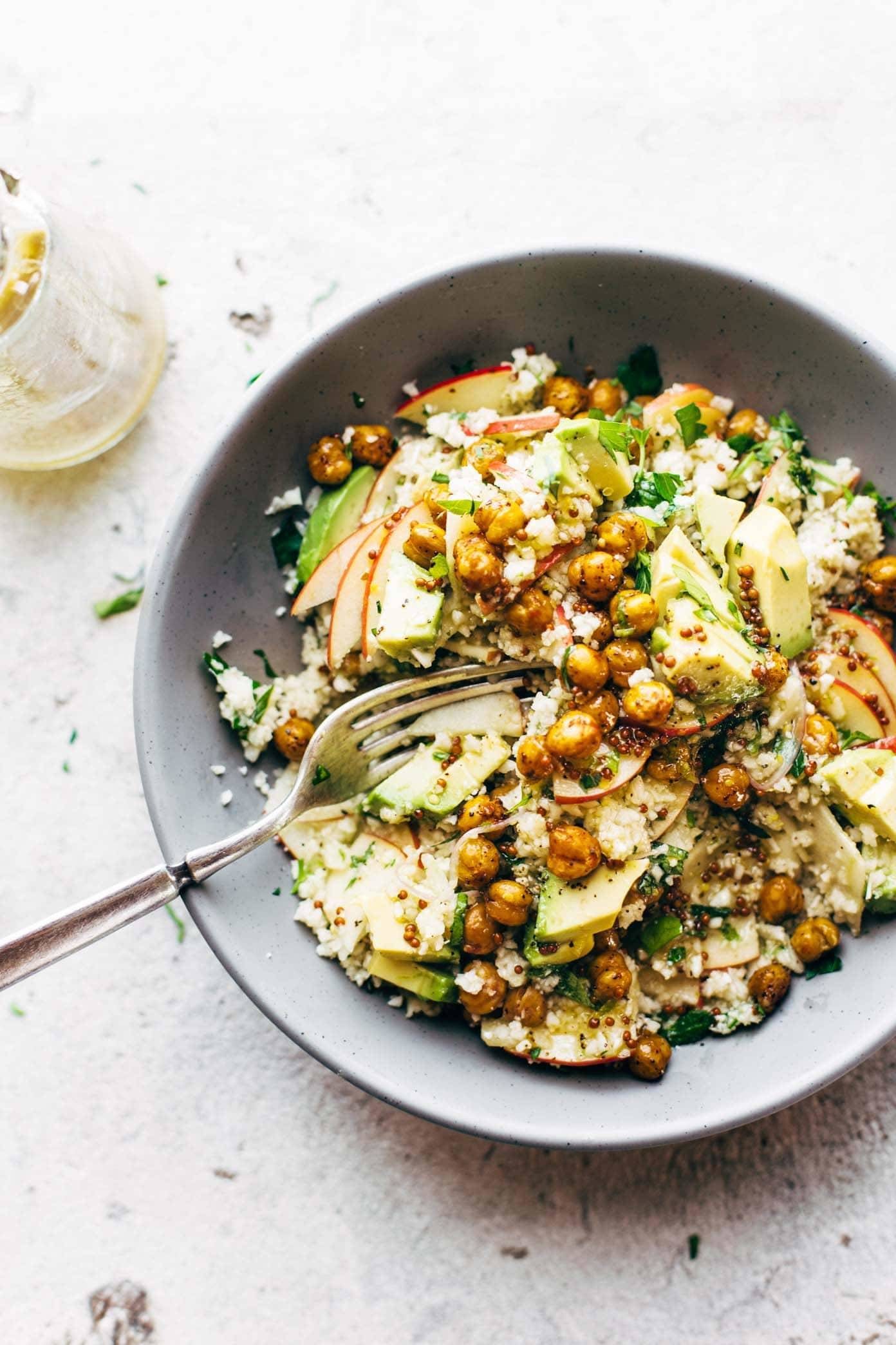 Fork in a bowl of chickpeas, veggies and rice.