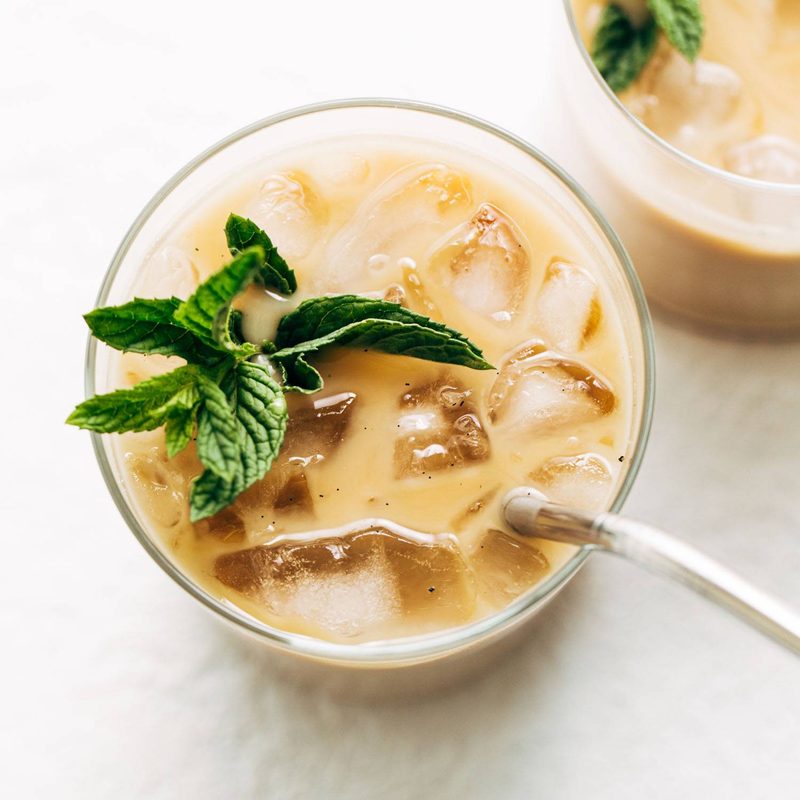 Vanilla mint iced coffee in a glad with ice and mint sprigs.